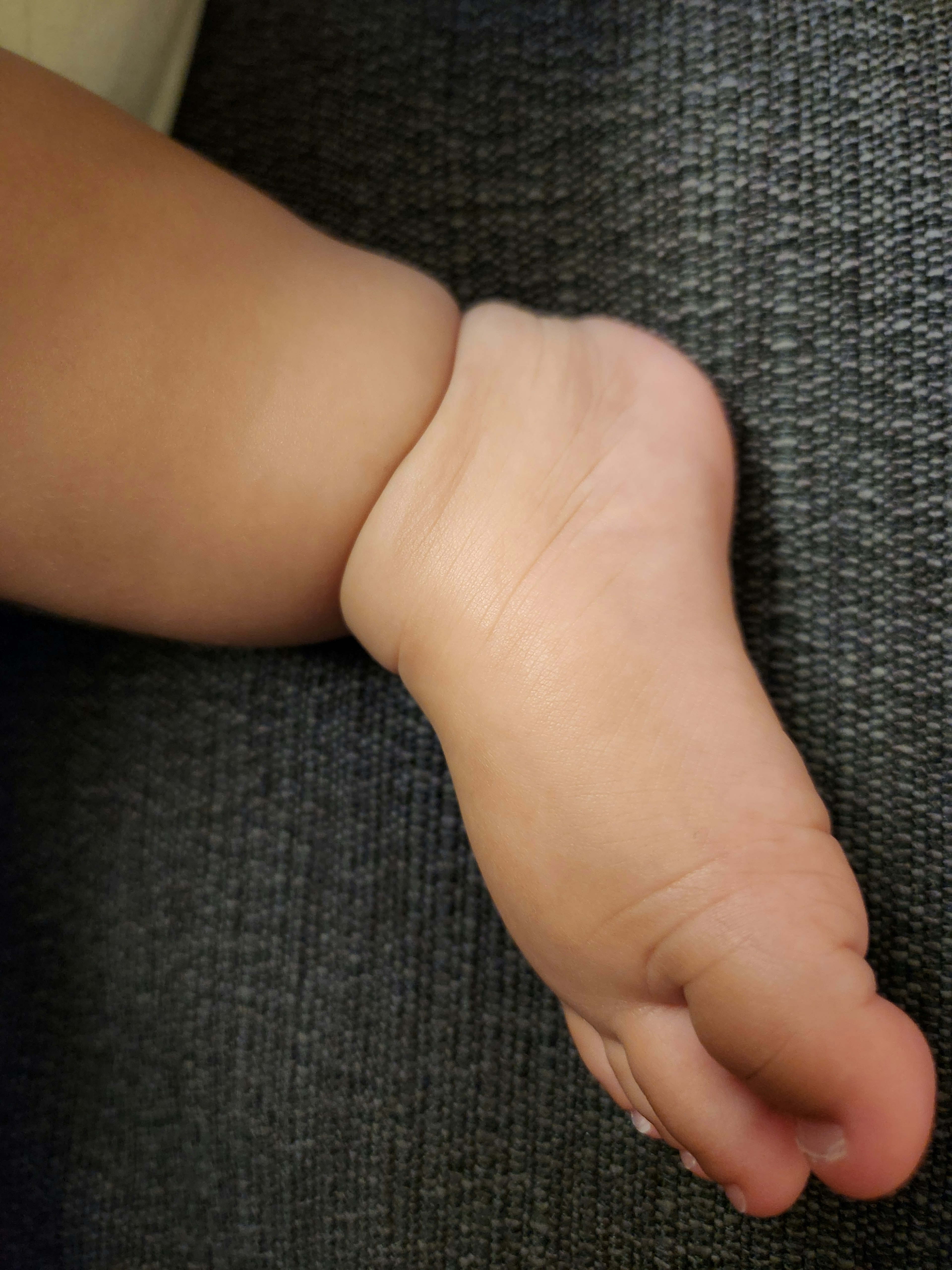 Baby foot resting on a couch