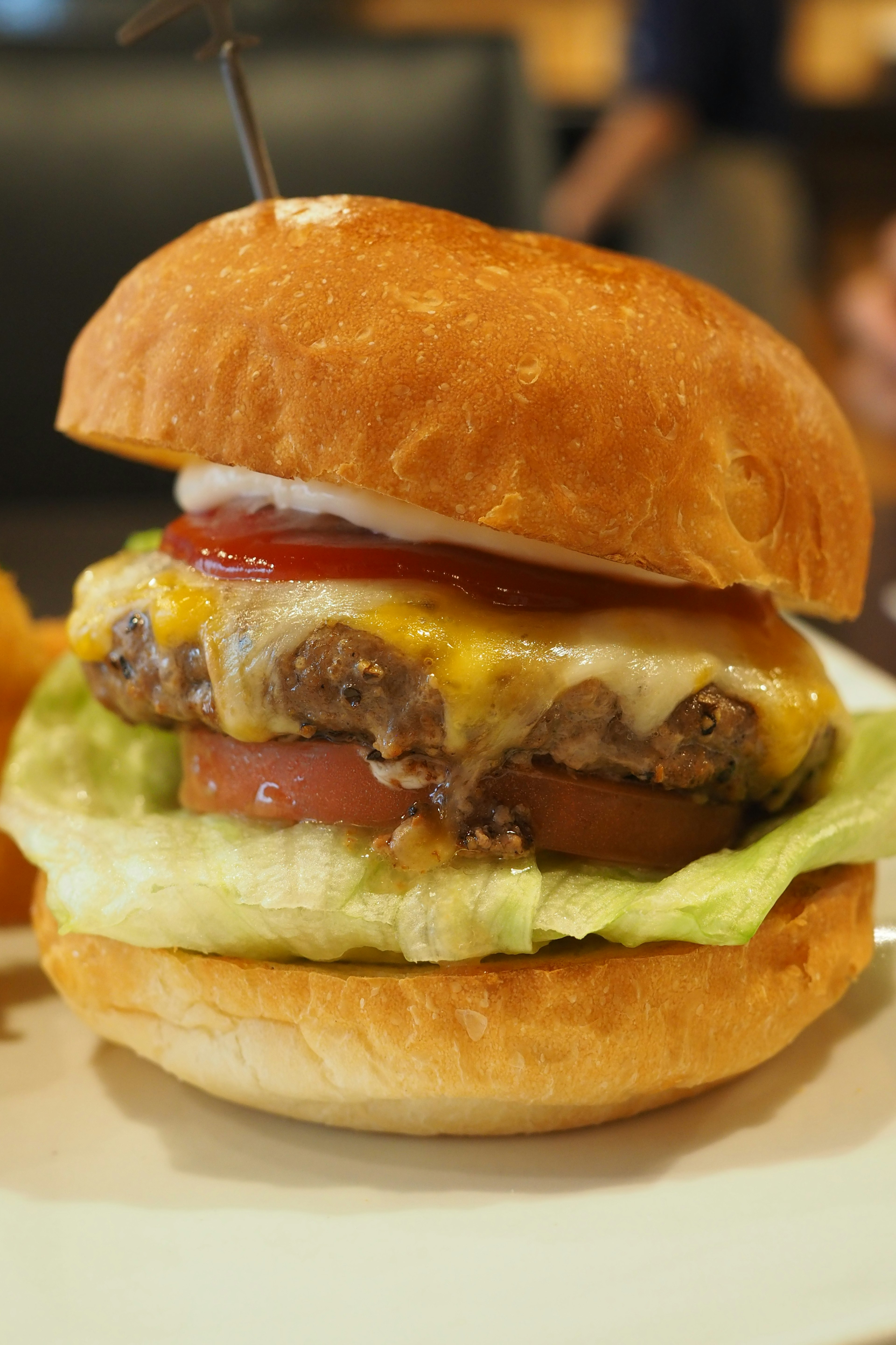 Hamburger lezat dengan selada, tomat, keju, dan saus tomat dalam roti