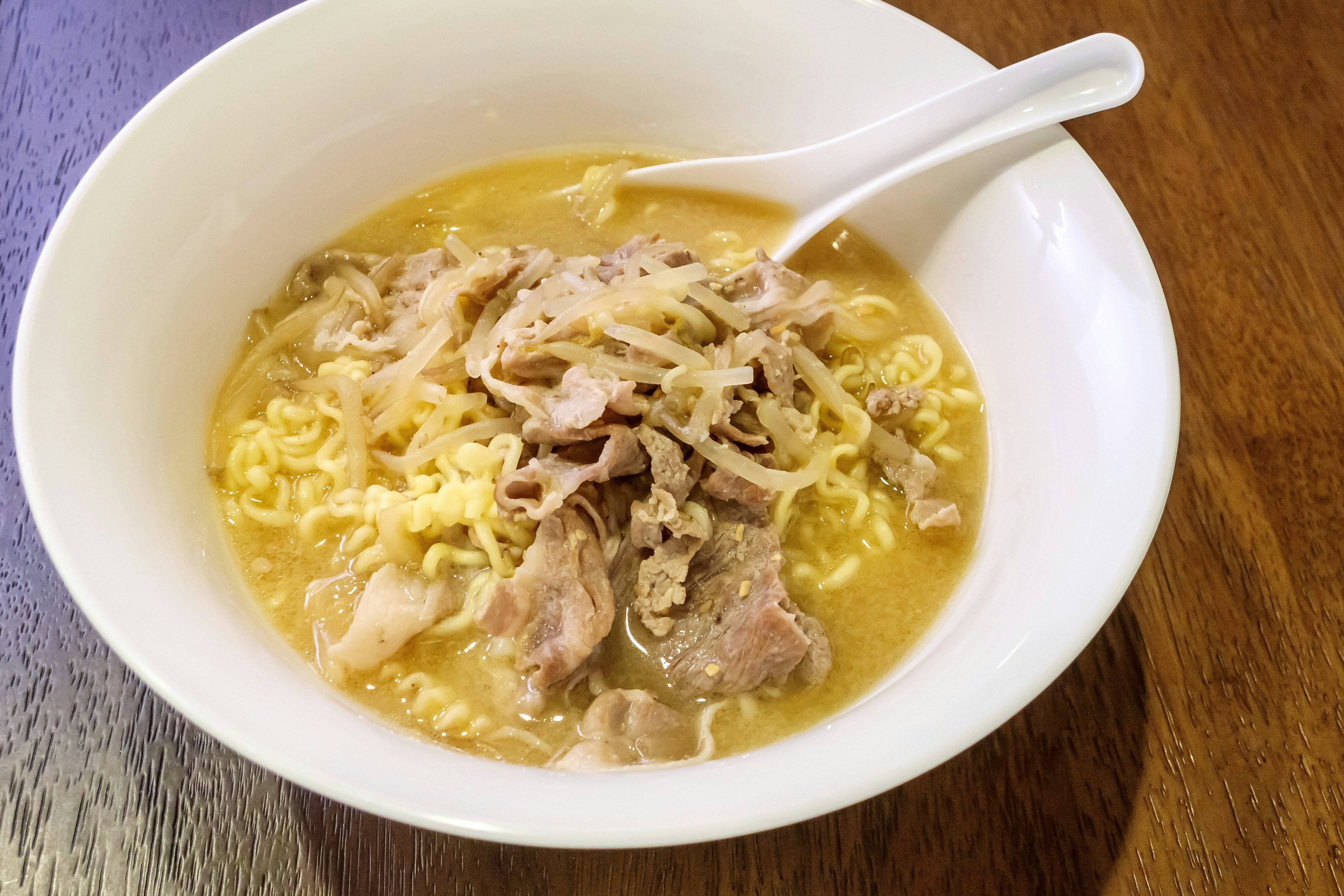 Bowl of ramen soup topped with sliced pork and noodles