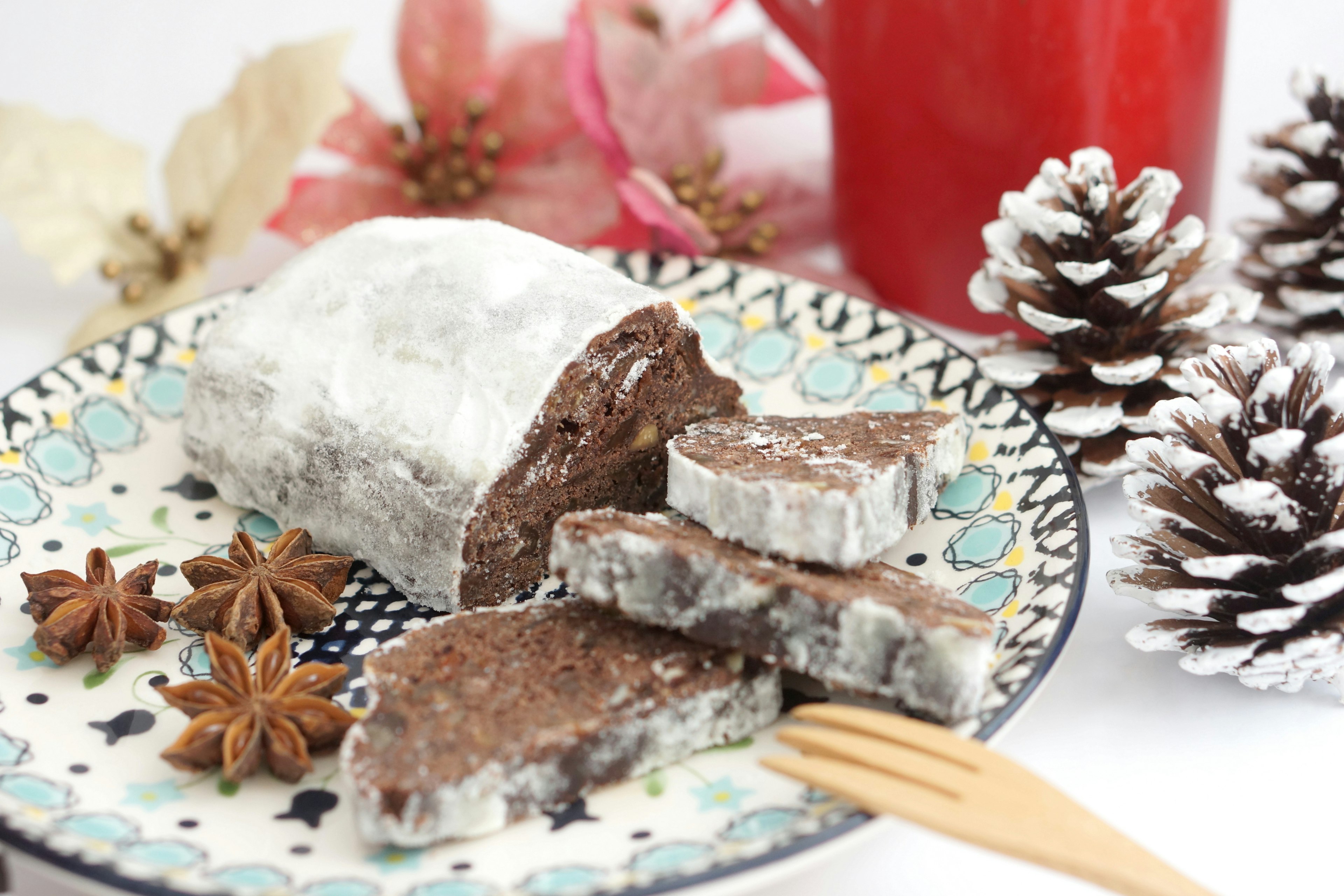 Schokoladendessert auf einem dekorativen Teller mit Weihnachtsdekorationen im Hintergrund