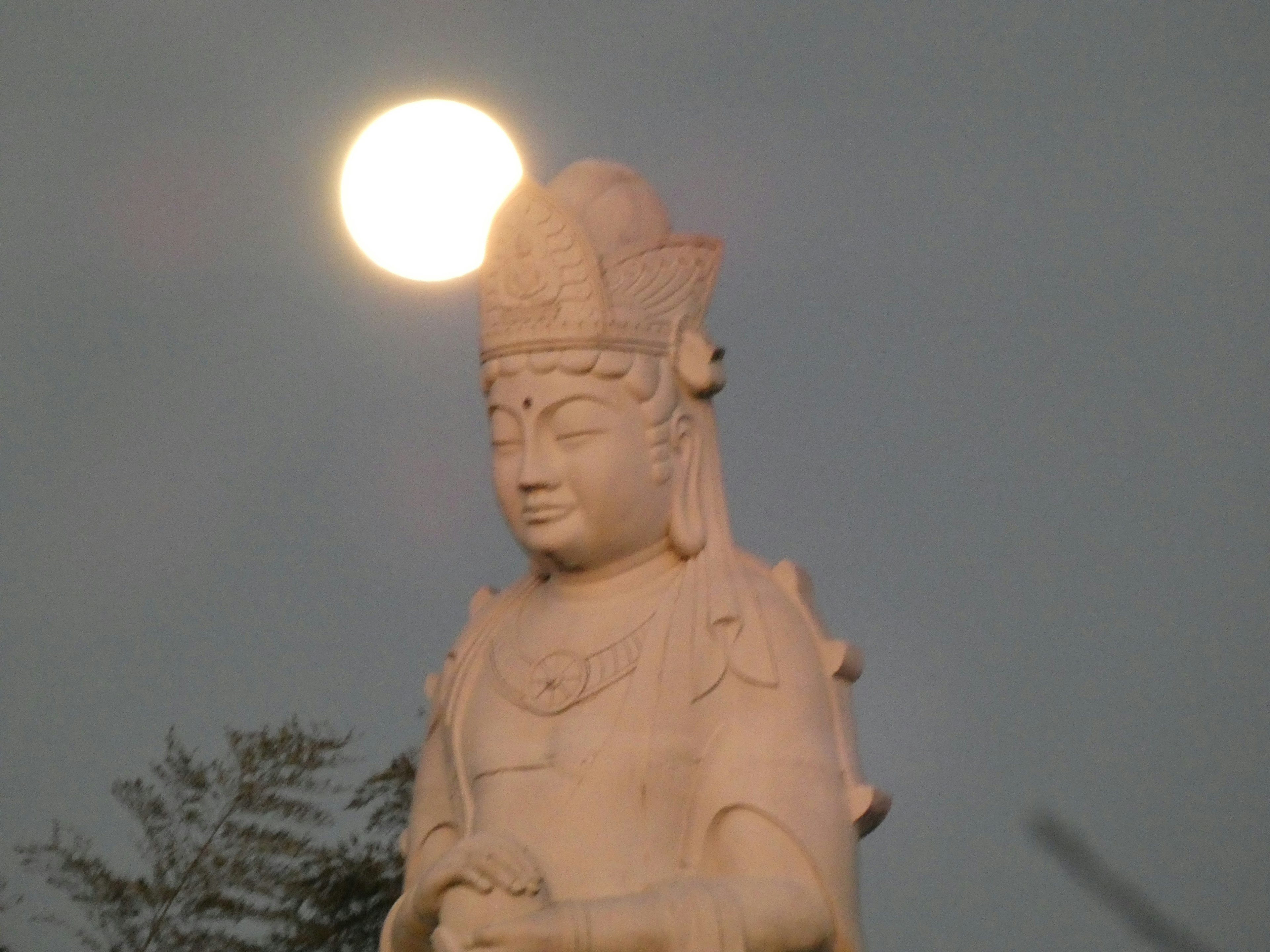 Hermosa escultura de una figura budista con la luna arriba