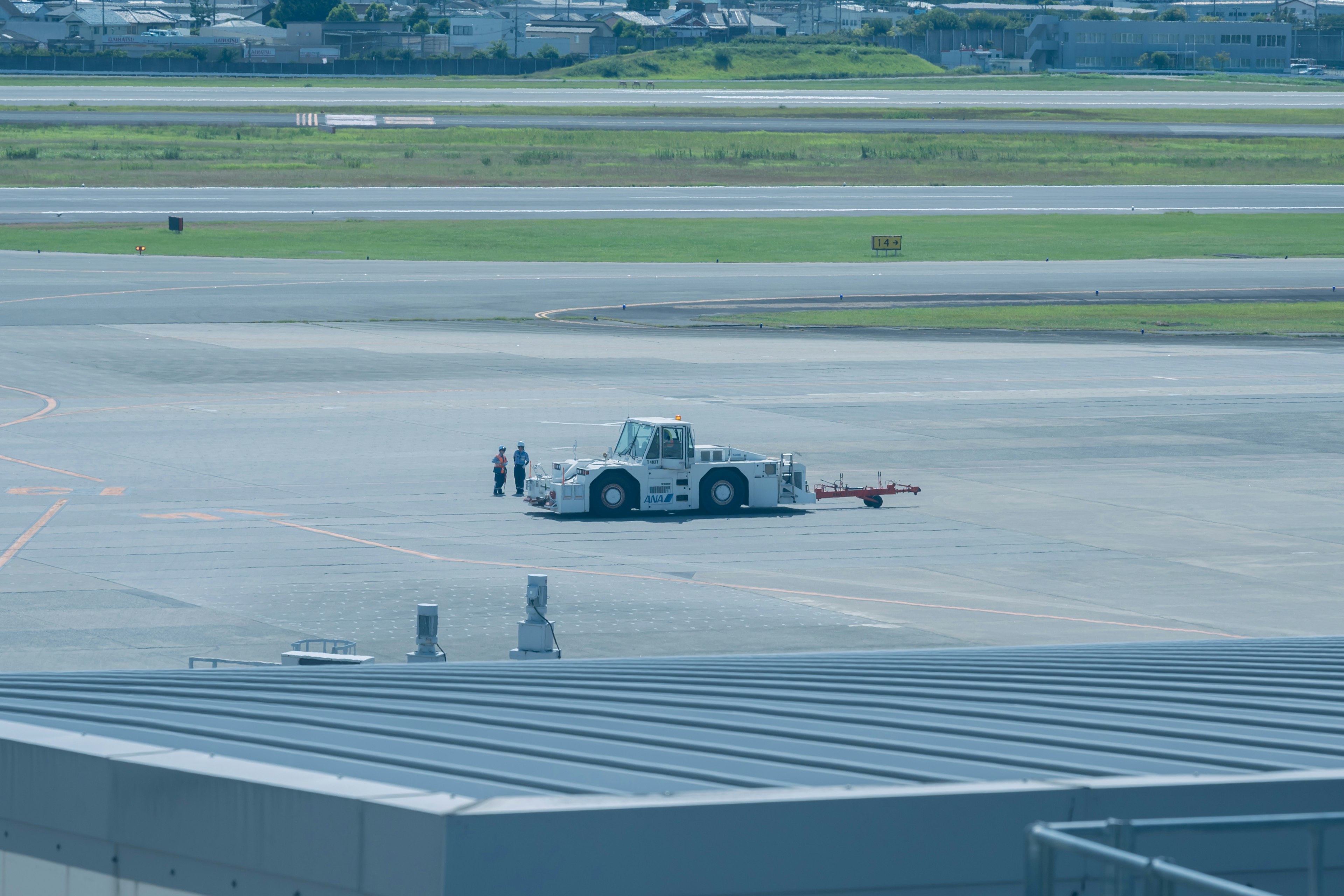 Trattore di rimorchio parcheggiato sulla pista dell'aeroporto con paesaggio circostante