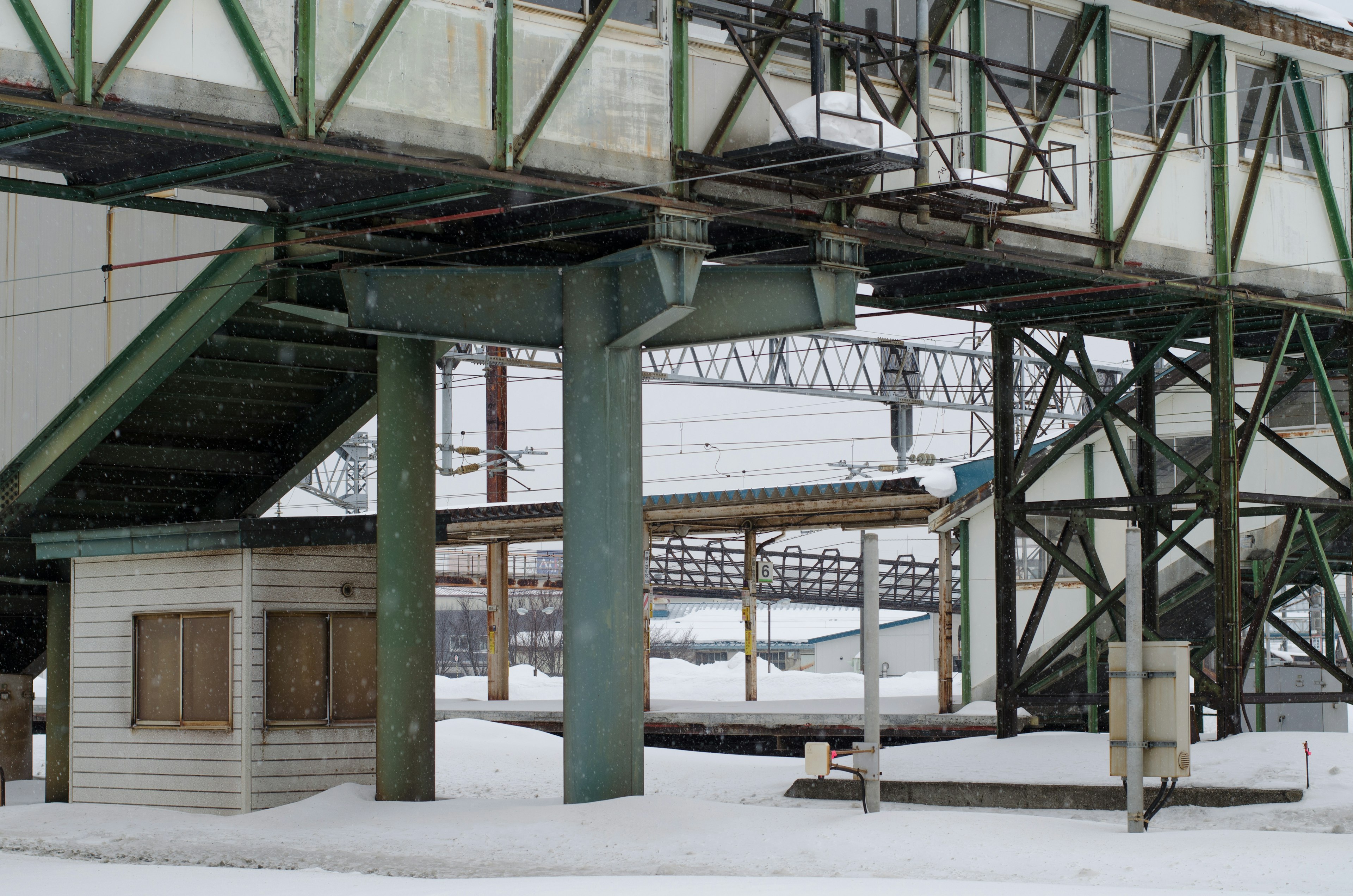 Snow-covered railway station structure with supporting pillars