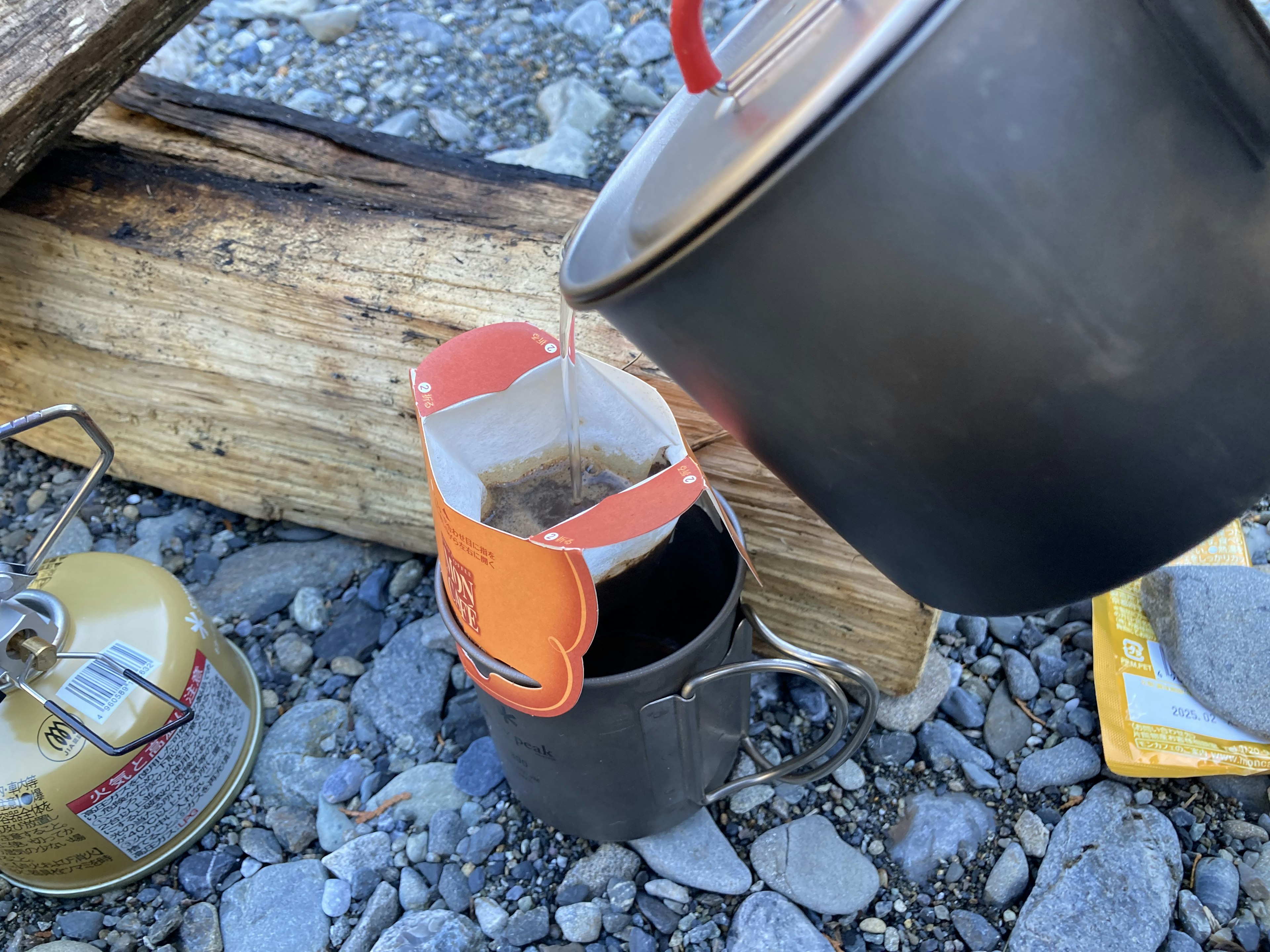 Szenen der Kaffeezubereitung im Freien mit einer Kaffeekanne aus Stahl und einer Tasse