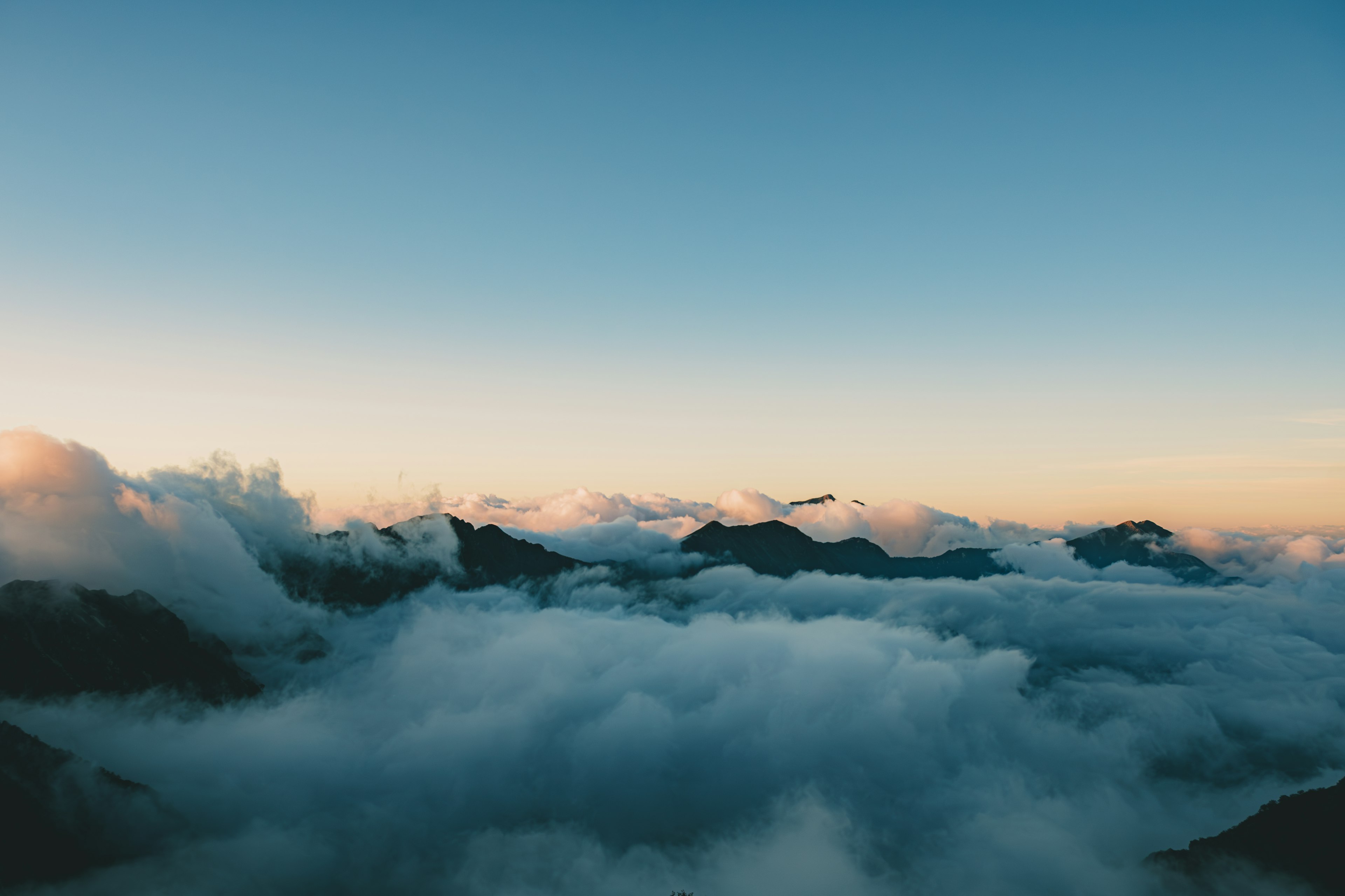 Pemandangan awan di atas pegunungan dengan langit biru