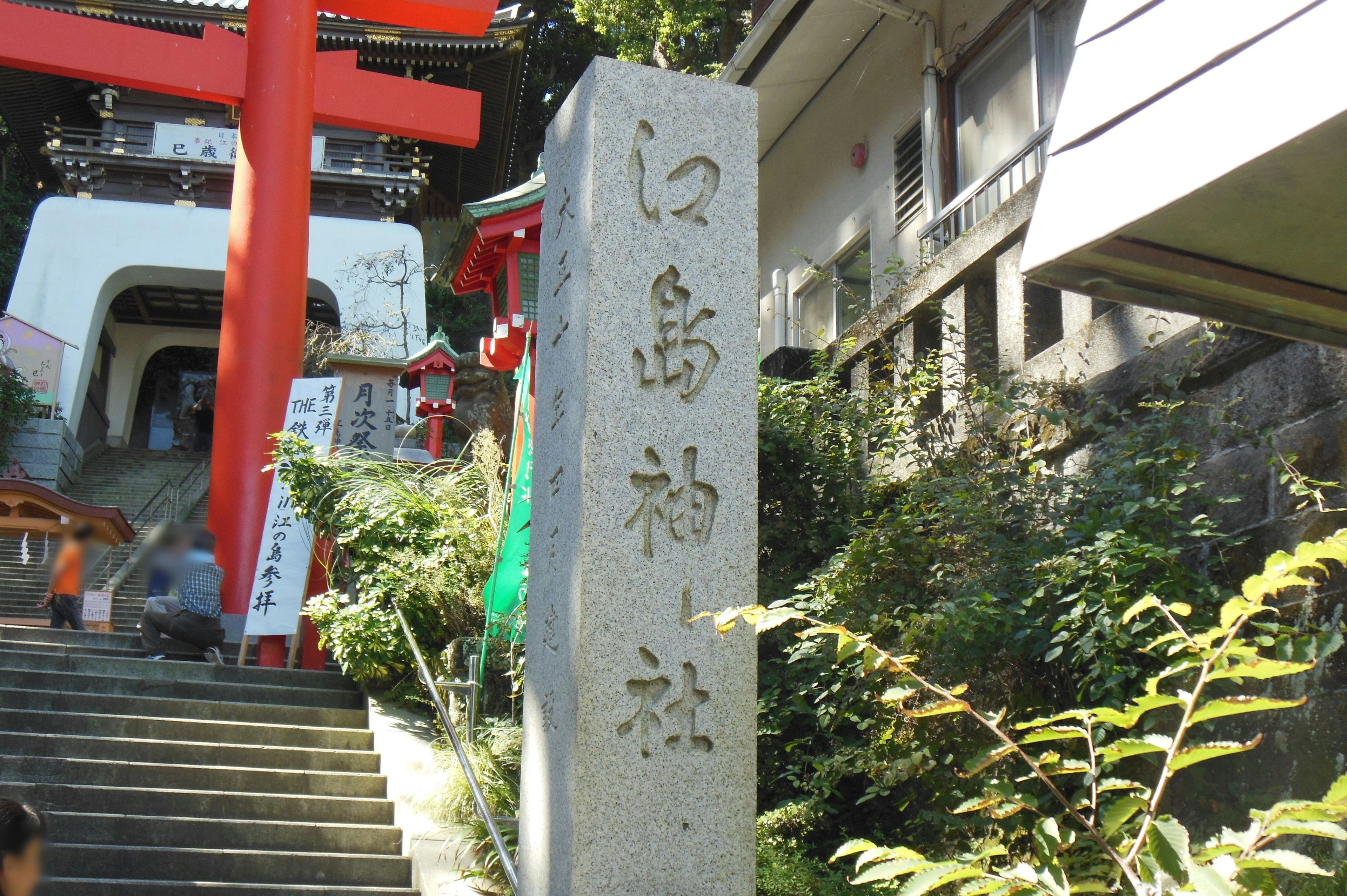 Monument en pierre d'un sanctuaire avec une porte torii rouge et des escaliers