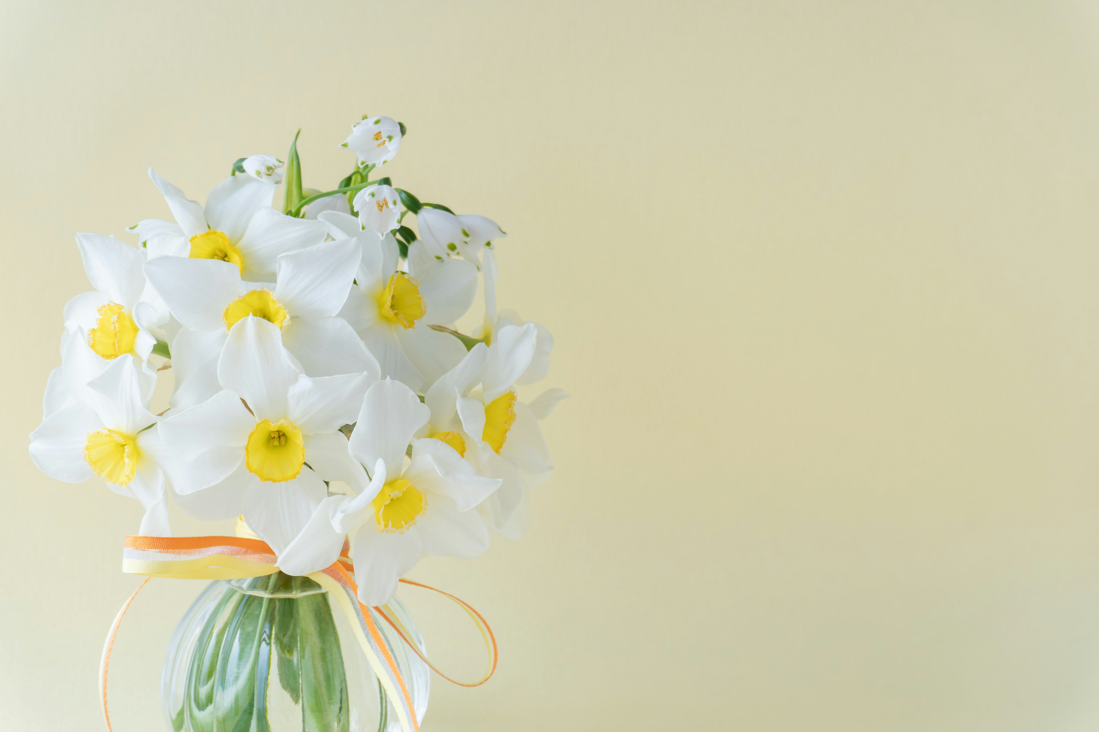 白い花と黄色い中心の花束が透明な瓶に入っている