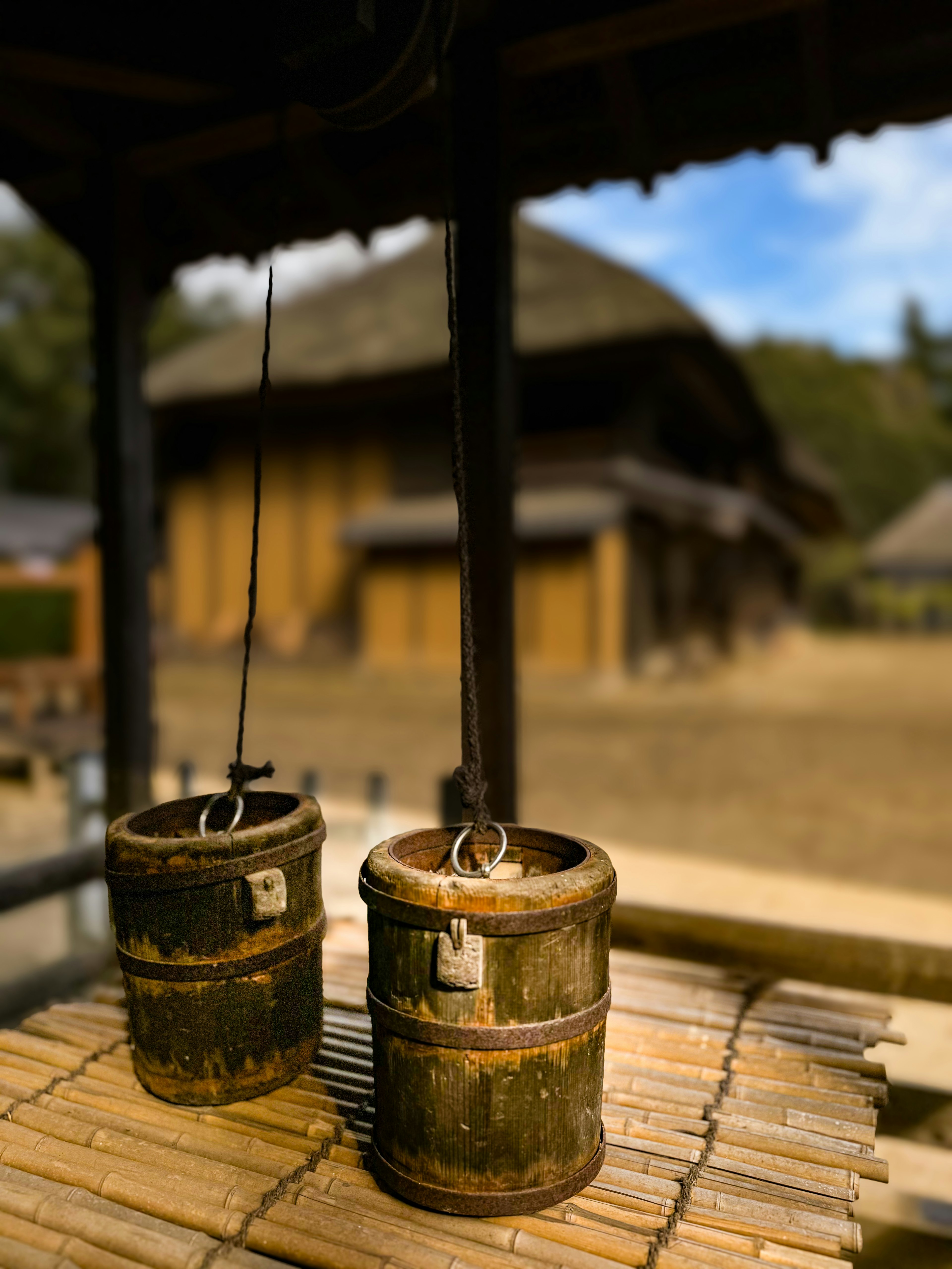 二つの竹製のバケツが水を汲むために吊り下げられている風景