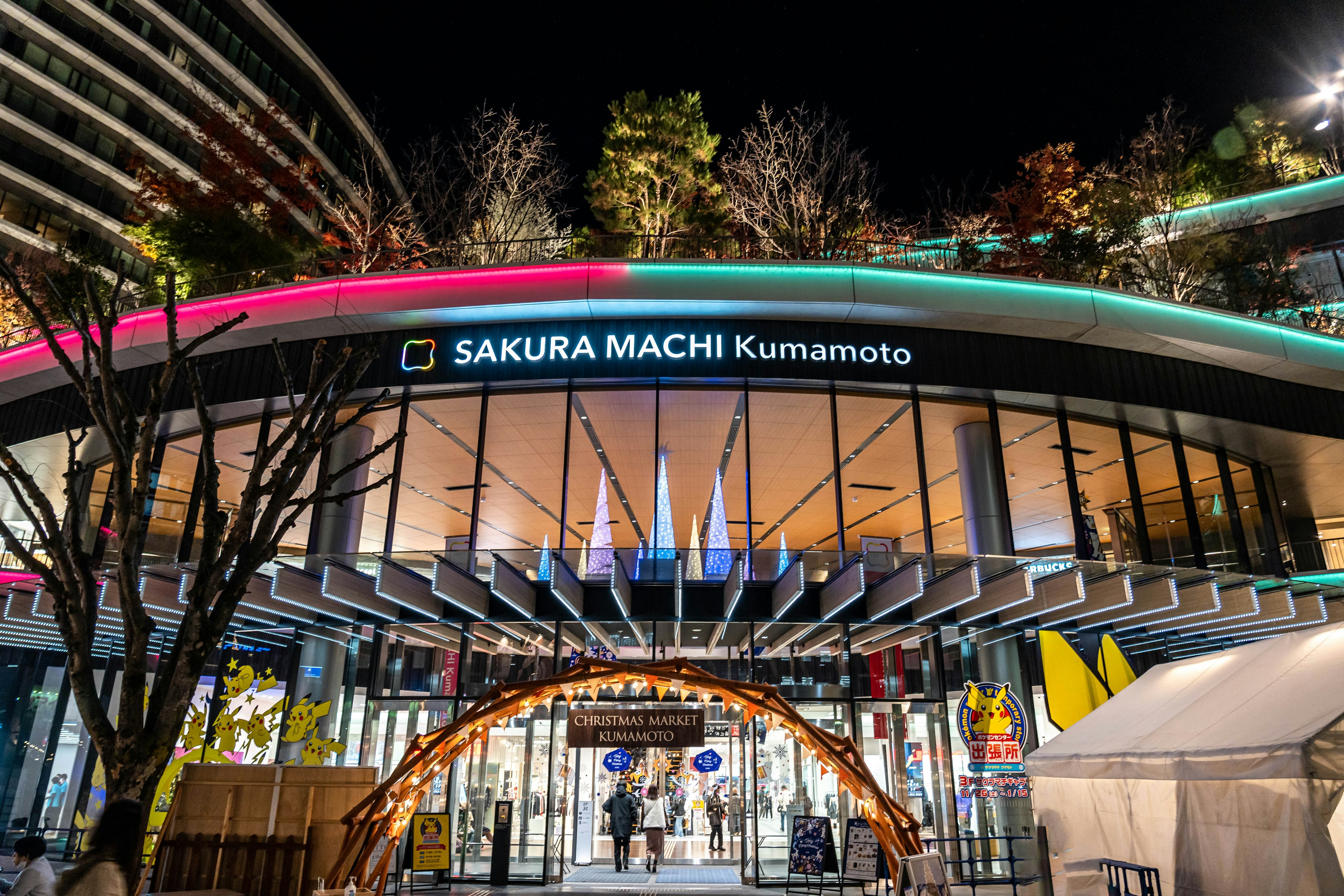 Bright entrance of Sakura Machi Kumamoto at night with colorful lighting