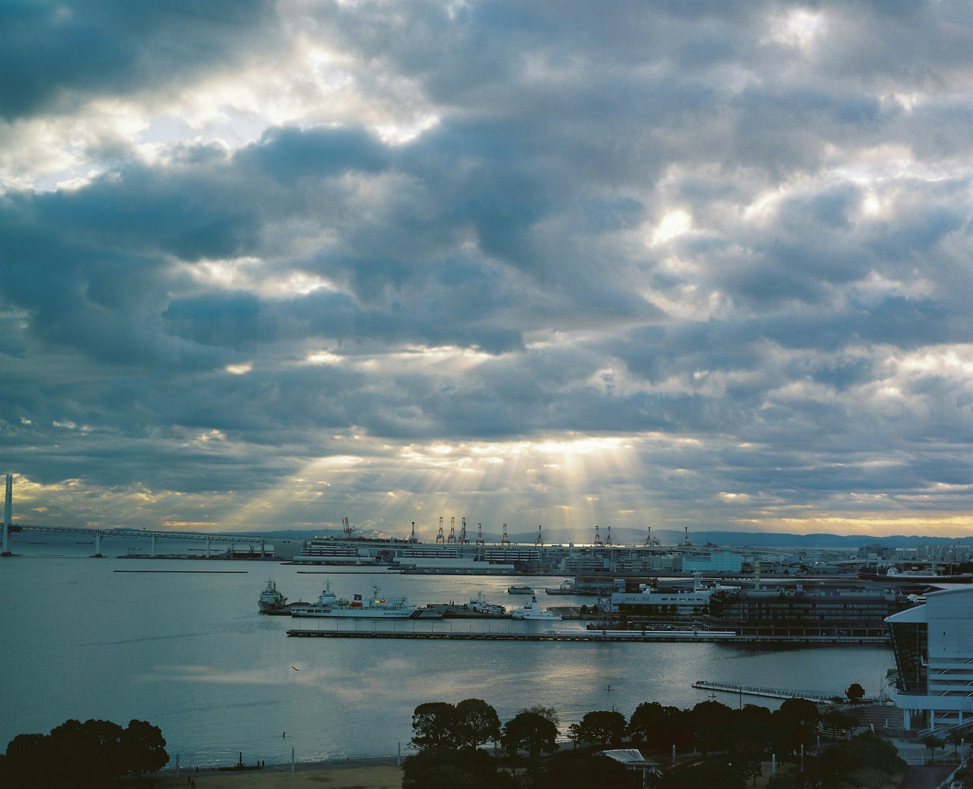 Vue d'un port avec de l'eau bleue et des nuages dramatiques des rayons de lumière perçant