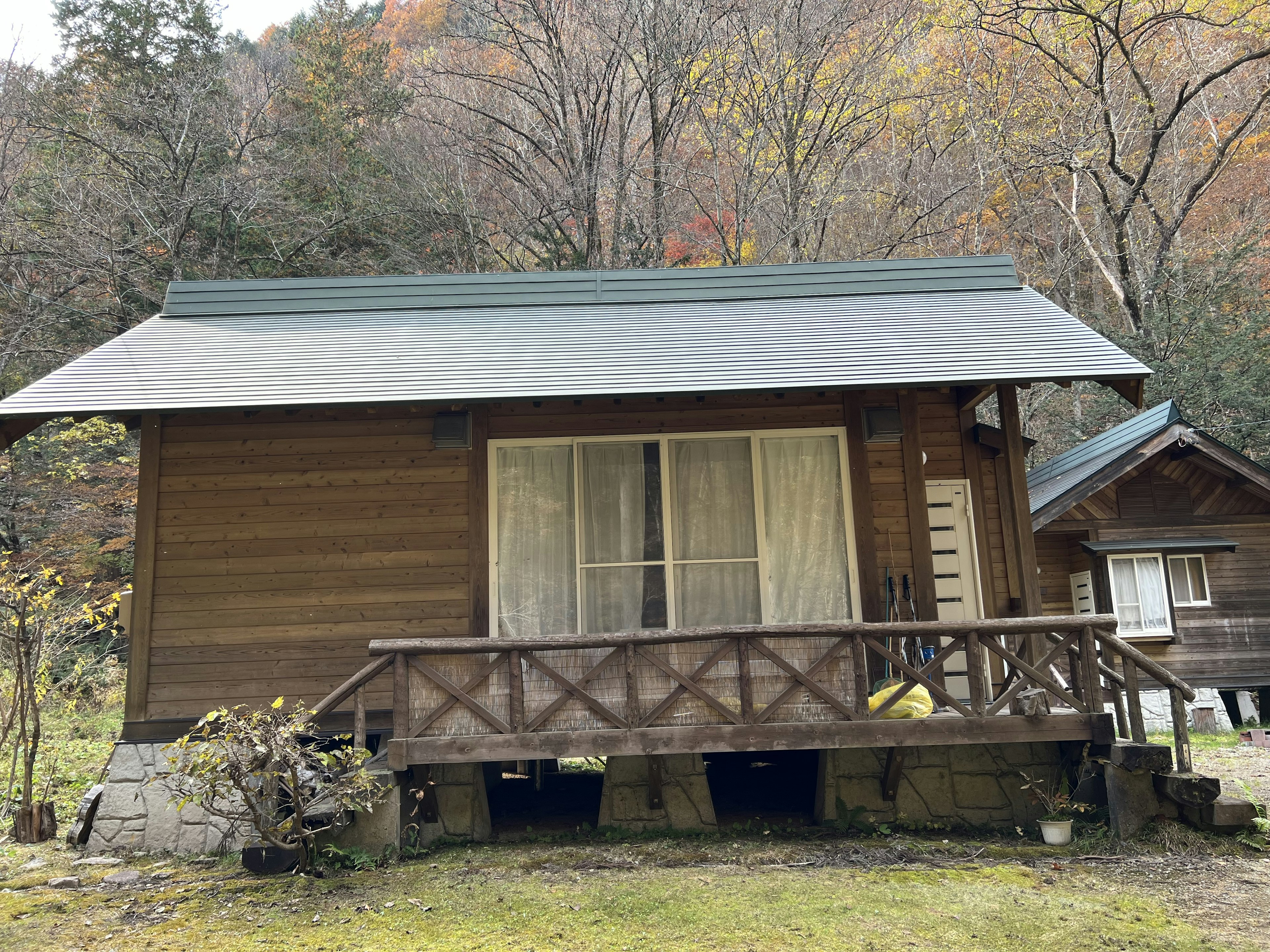 木製の小屋が秋の風景に囲まれている