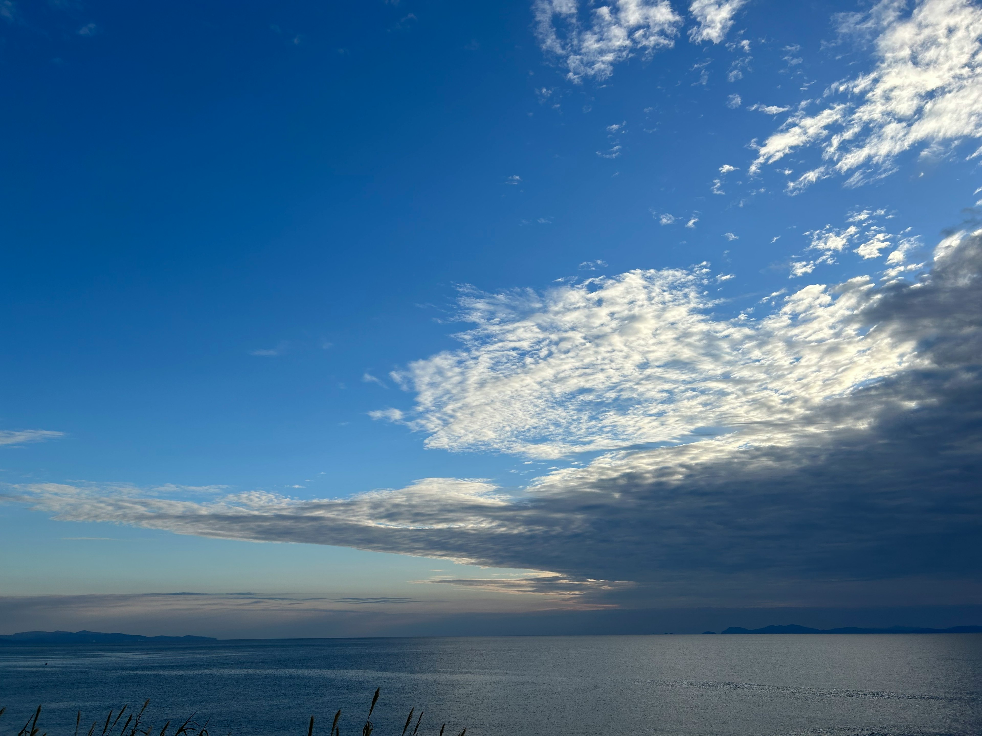 Malersiche Aussicht auf den blauen Himmel mit weißen Wolken über dem ruhigen Meer