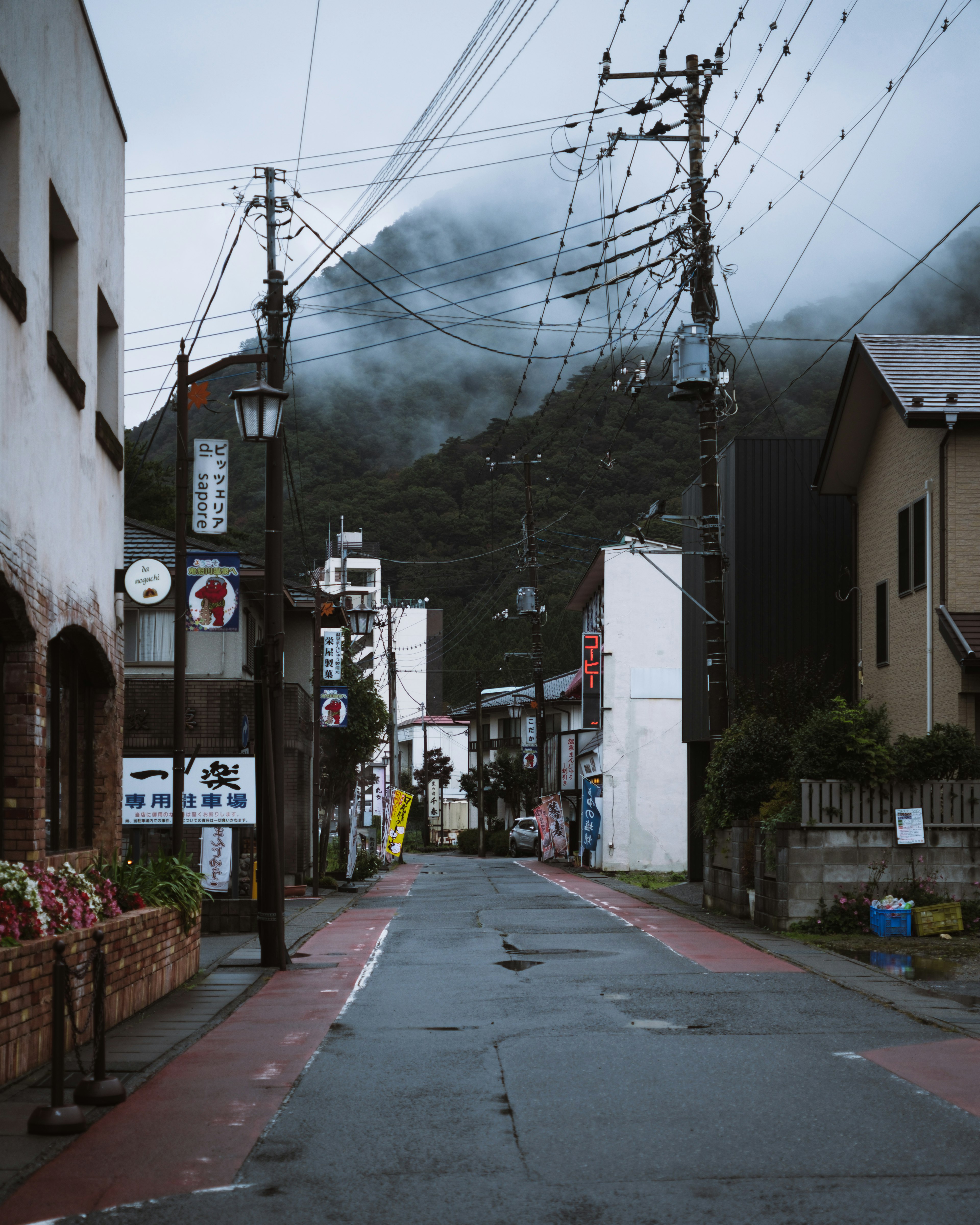 Calle tranquila en un día nublado con fondo montañoso