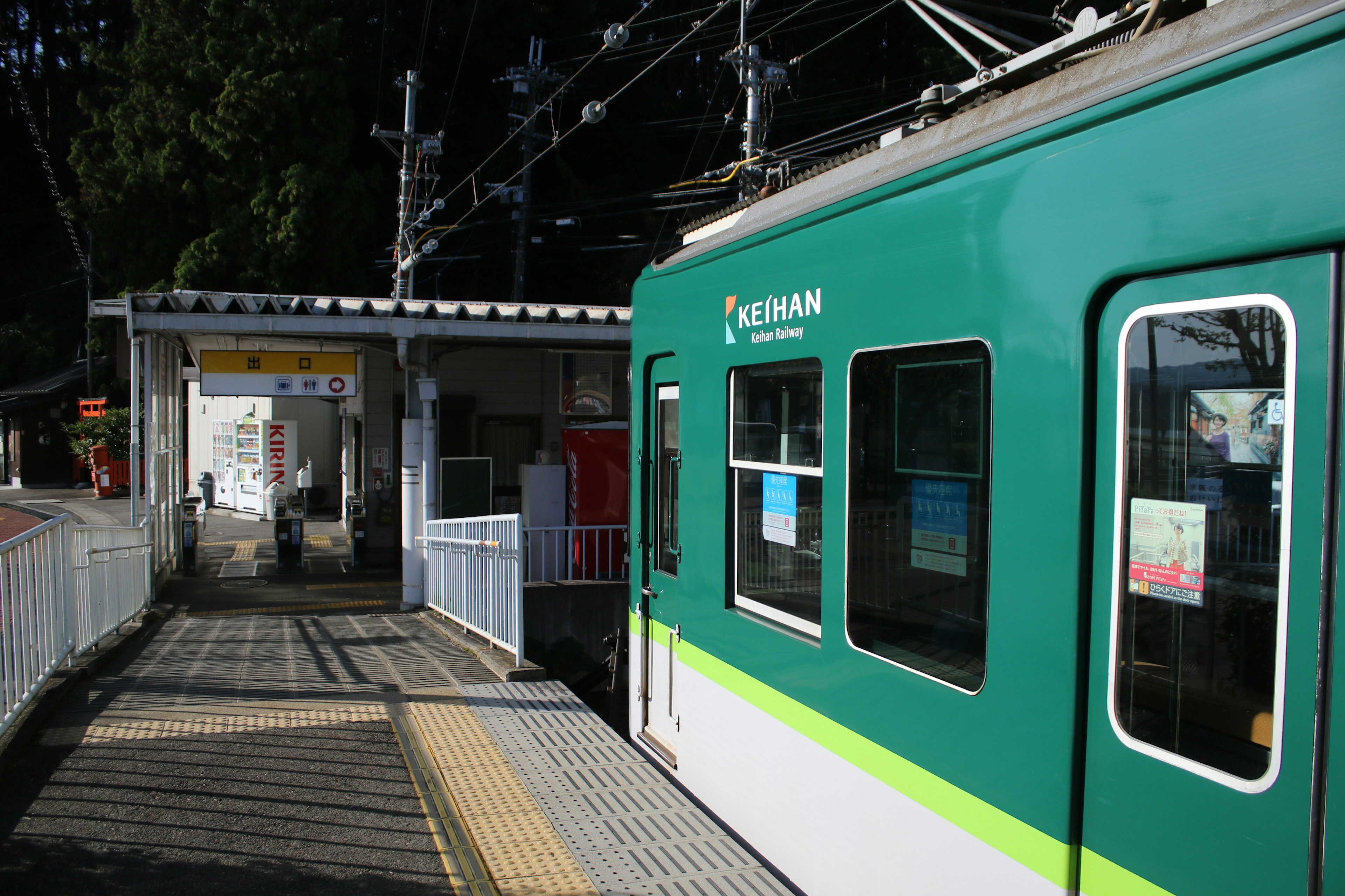 Green train stopped at a station with visible platform