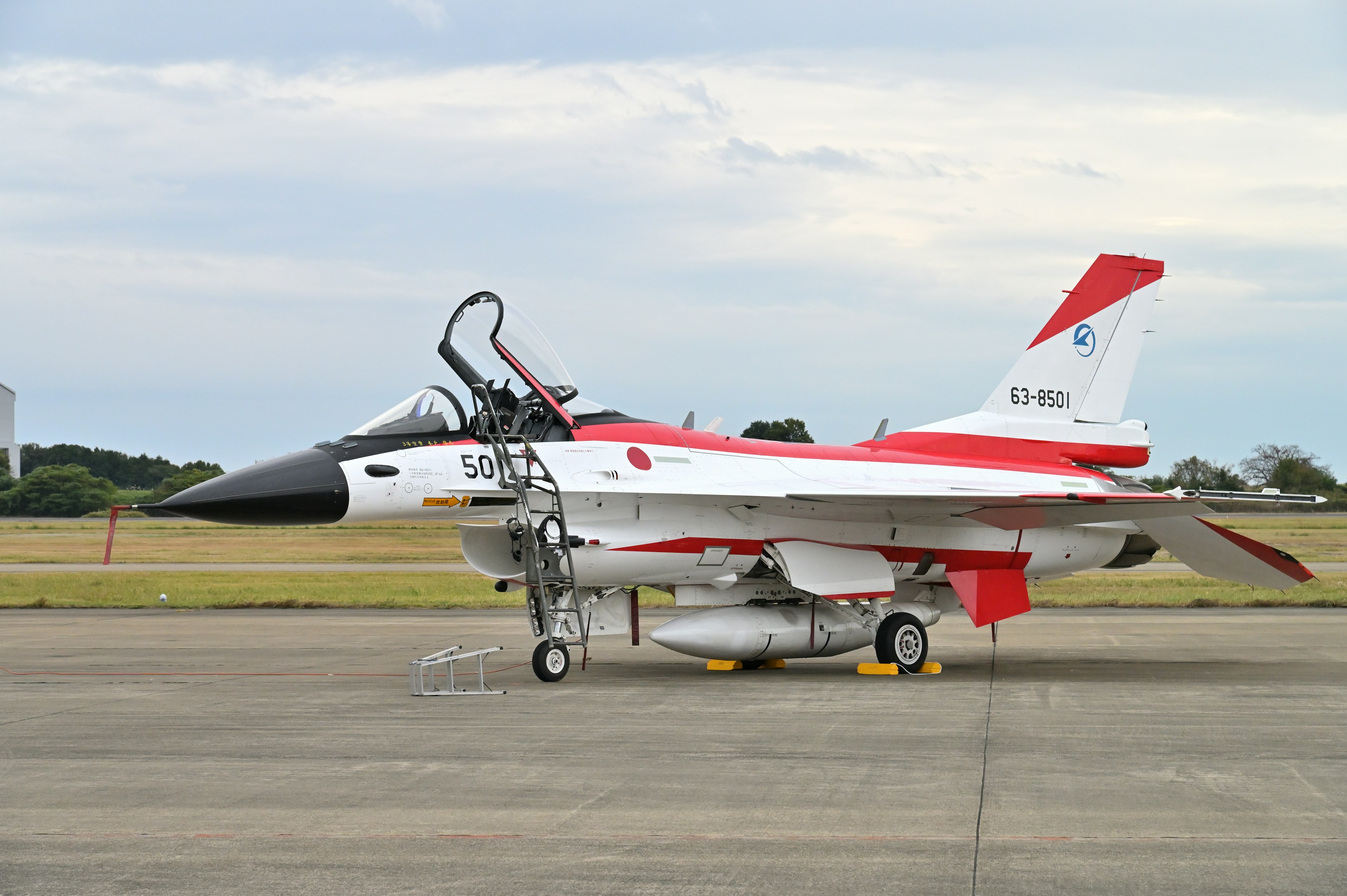 A red and white painted fighter jet is standing on the runway