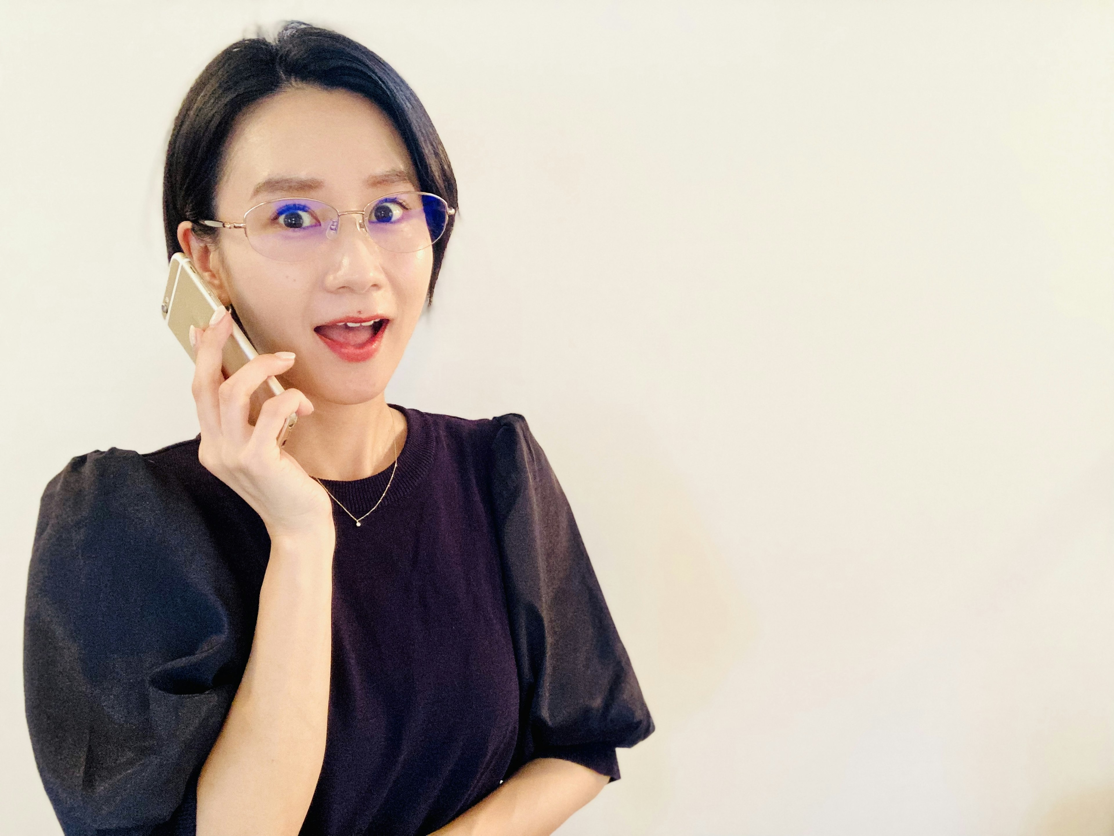 A woman talking on a mobile phone with a surprised expression