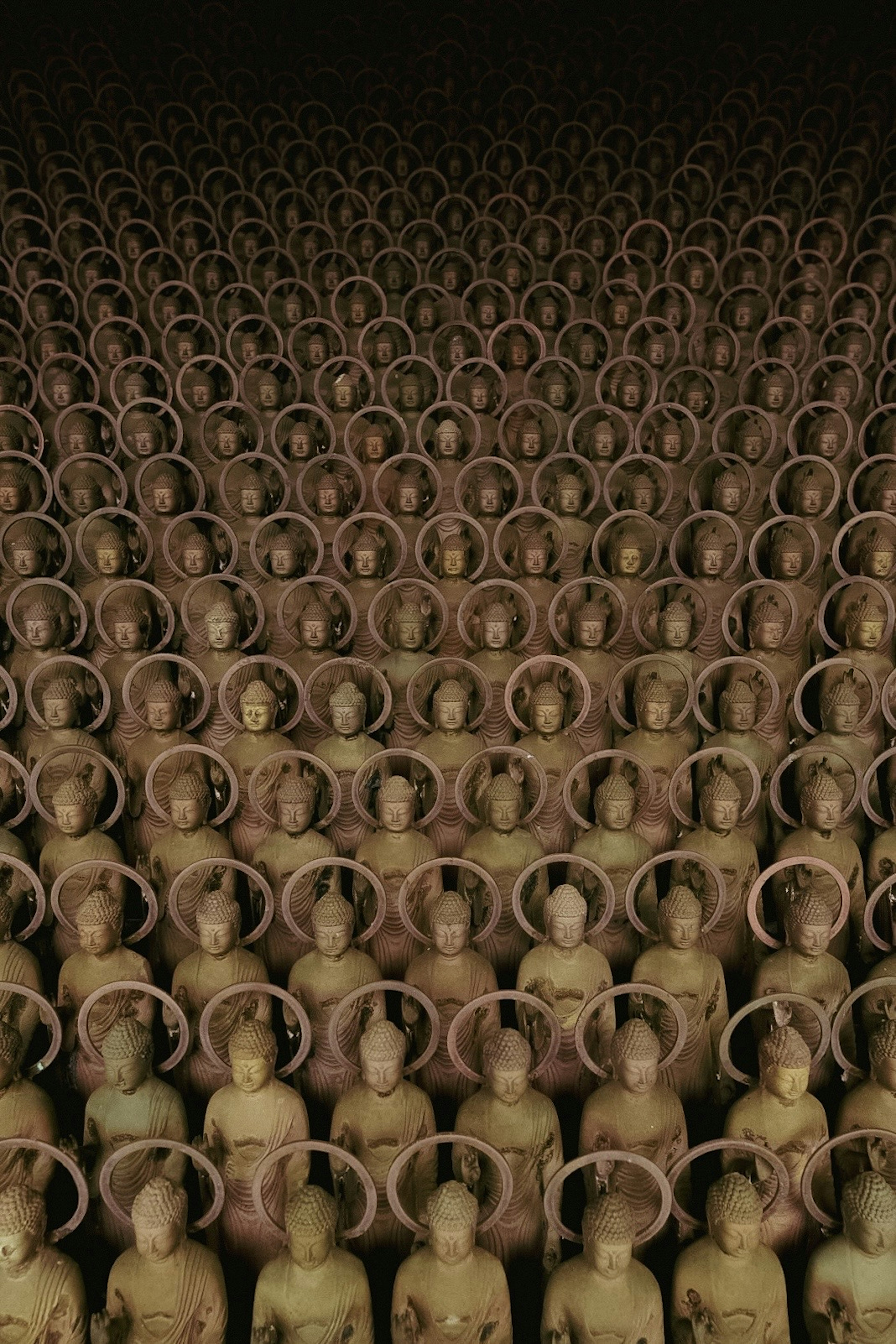 Countless statues of Buddha arranged in orderly rows