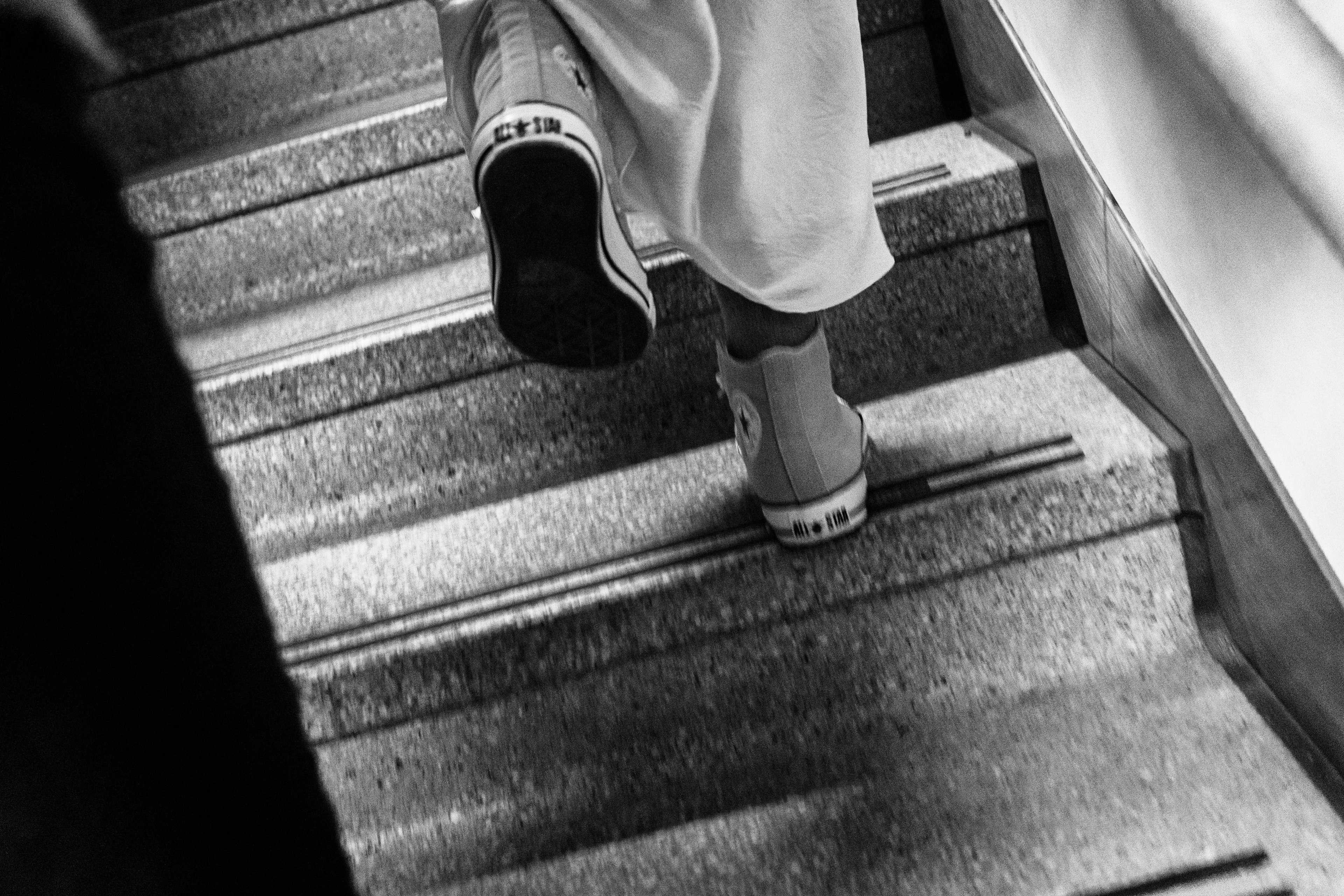 Black and white photo of feet ascending stairs featuring unique shoe designs