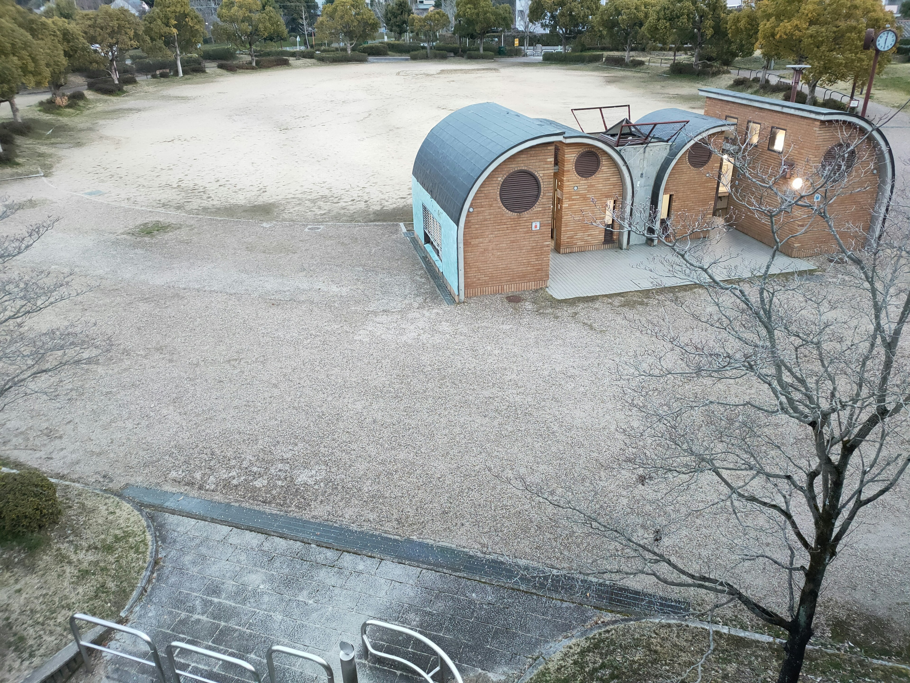 Ein geräumiger Park mit zwei bogenförmigen Gebäuden und trockenem Boden