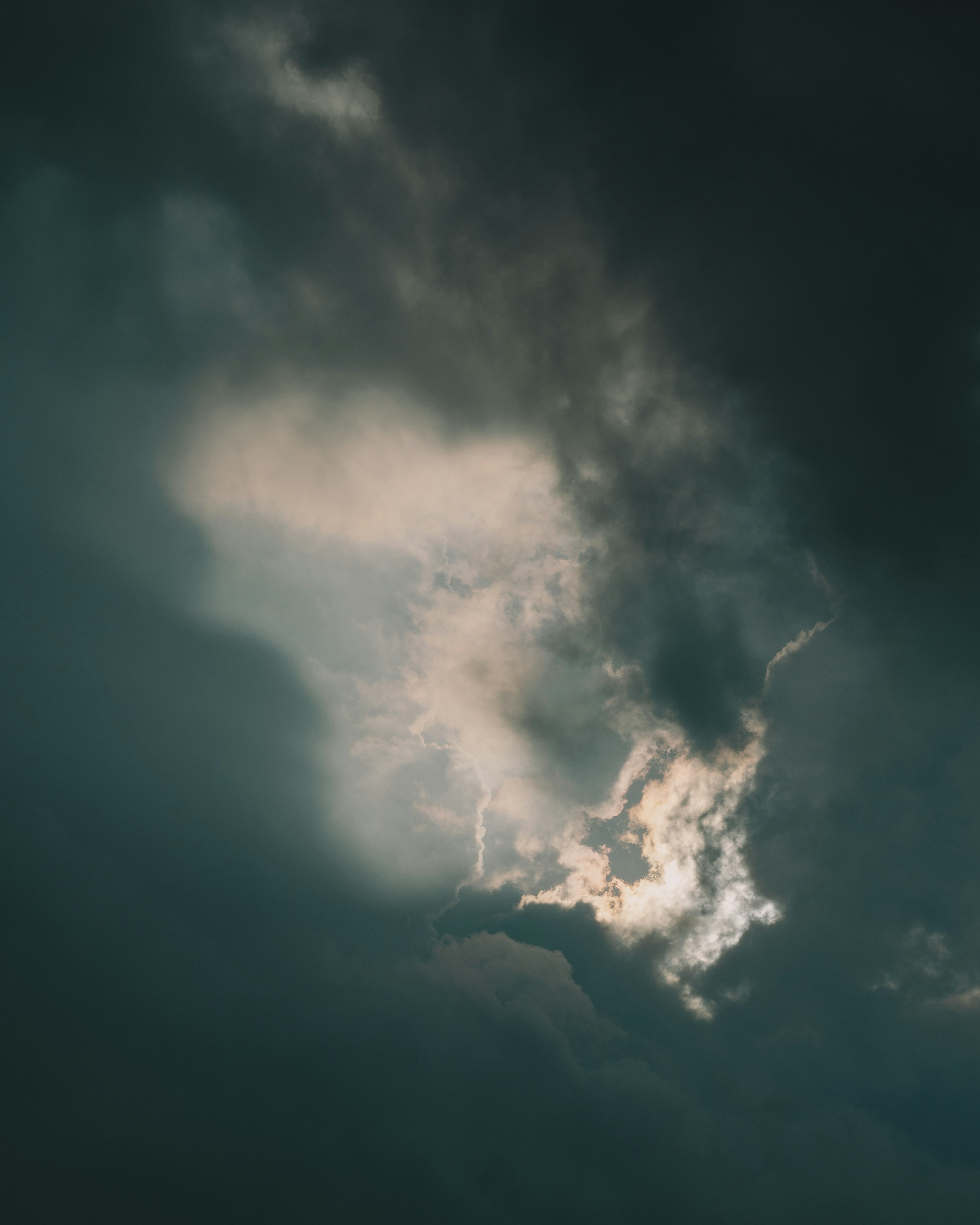 暗い雲の中から光が差し込む神秘的な空の風景