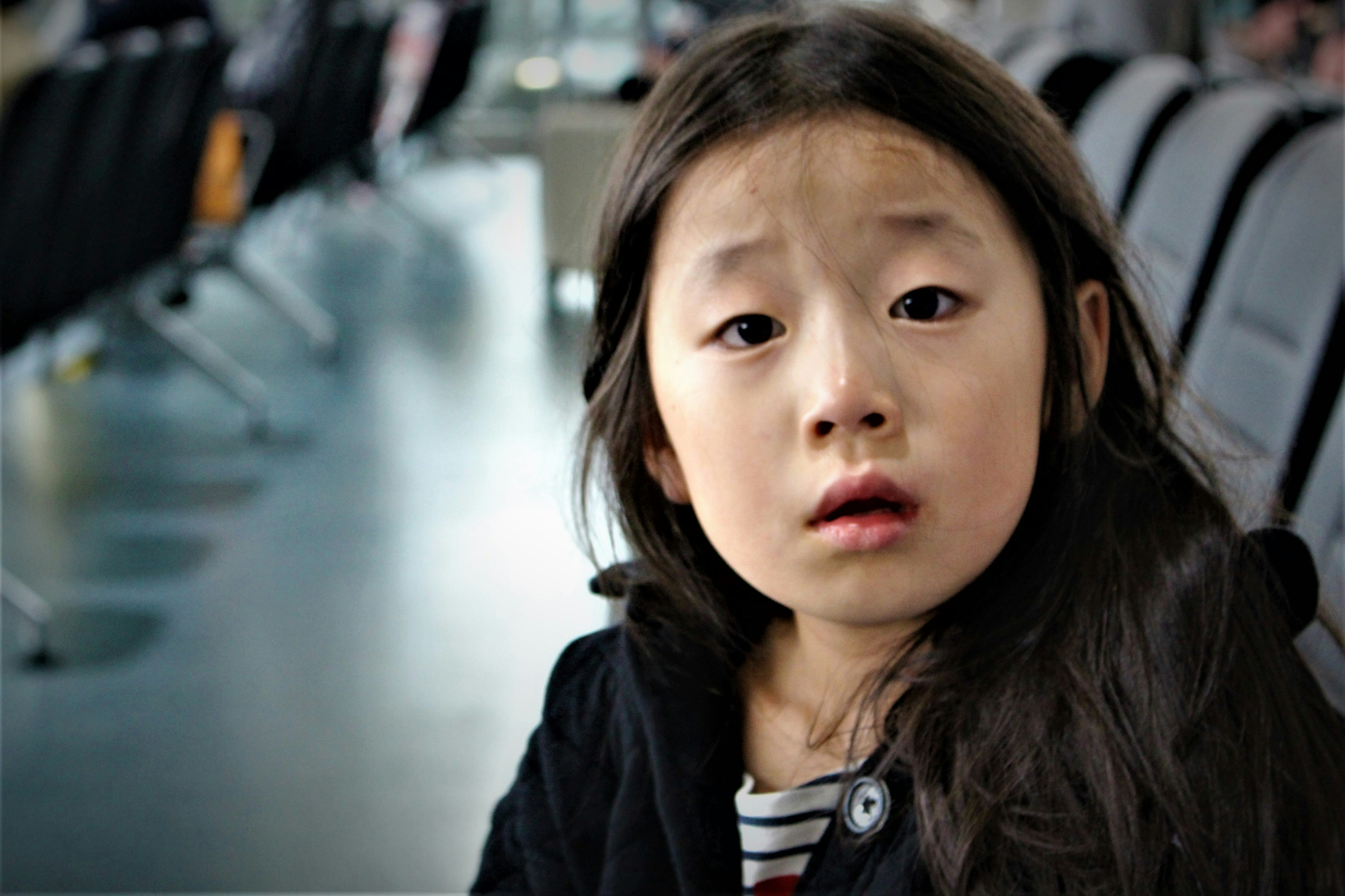 Une fille avec une expression surprise assise dans une salle d'attente