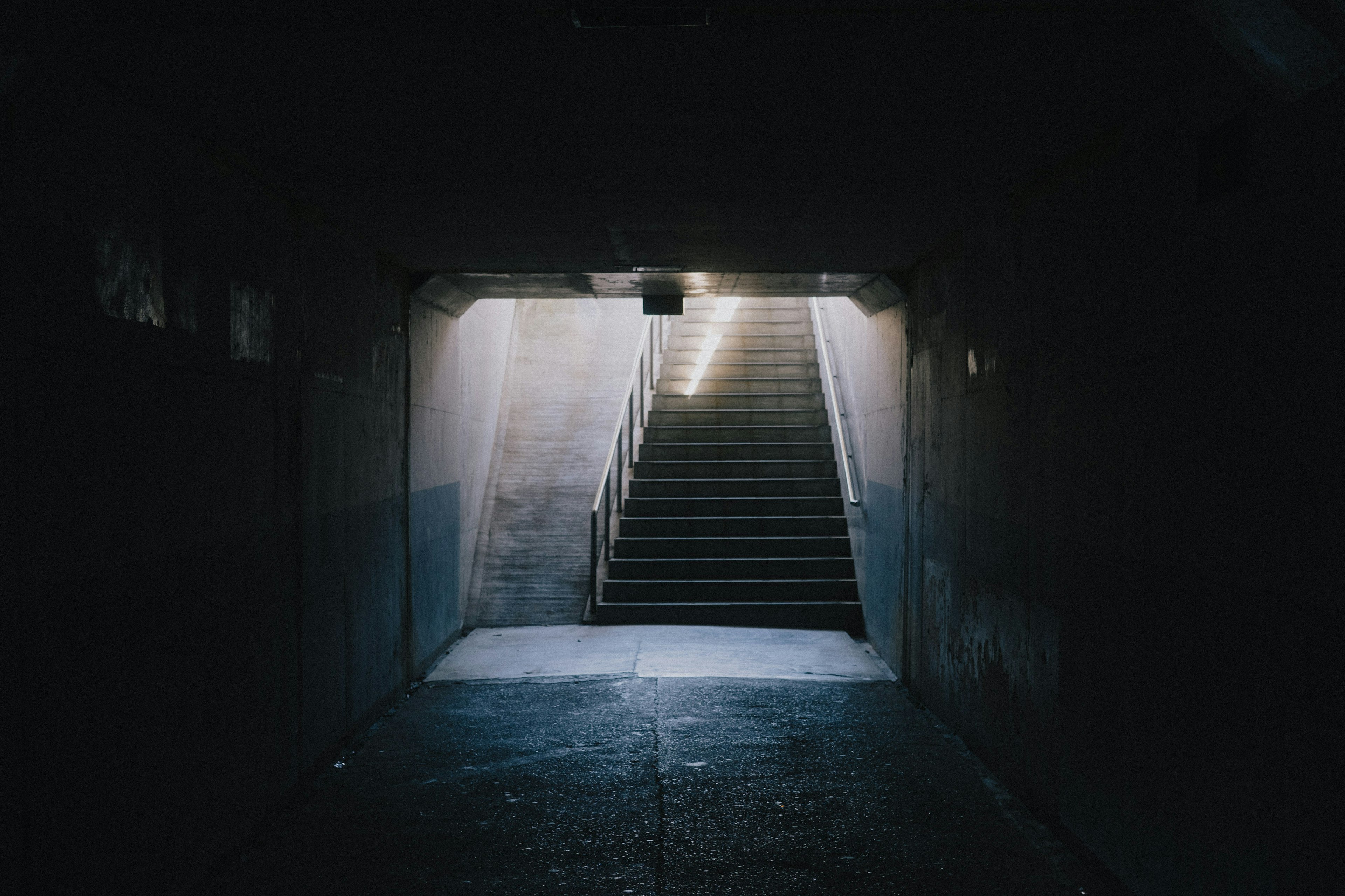 Túnel oscuro con escaleras brillantes al final