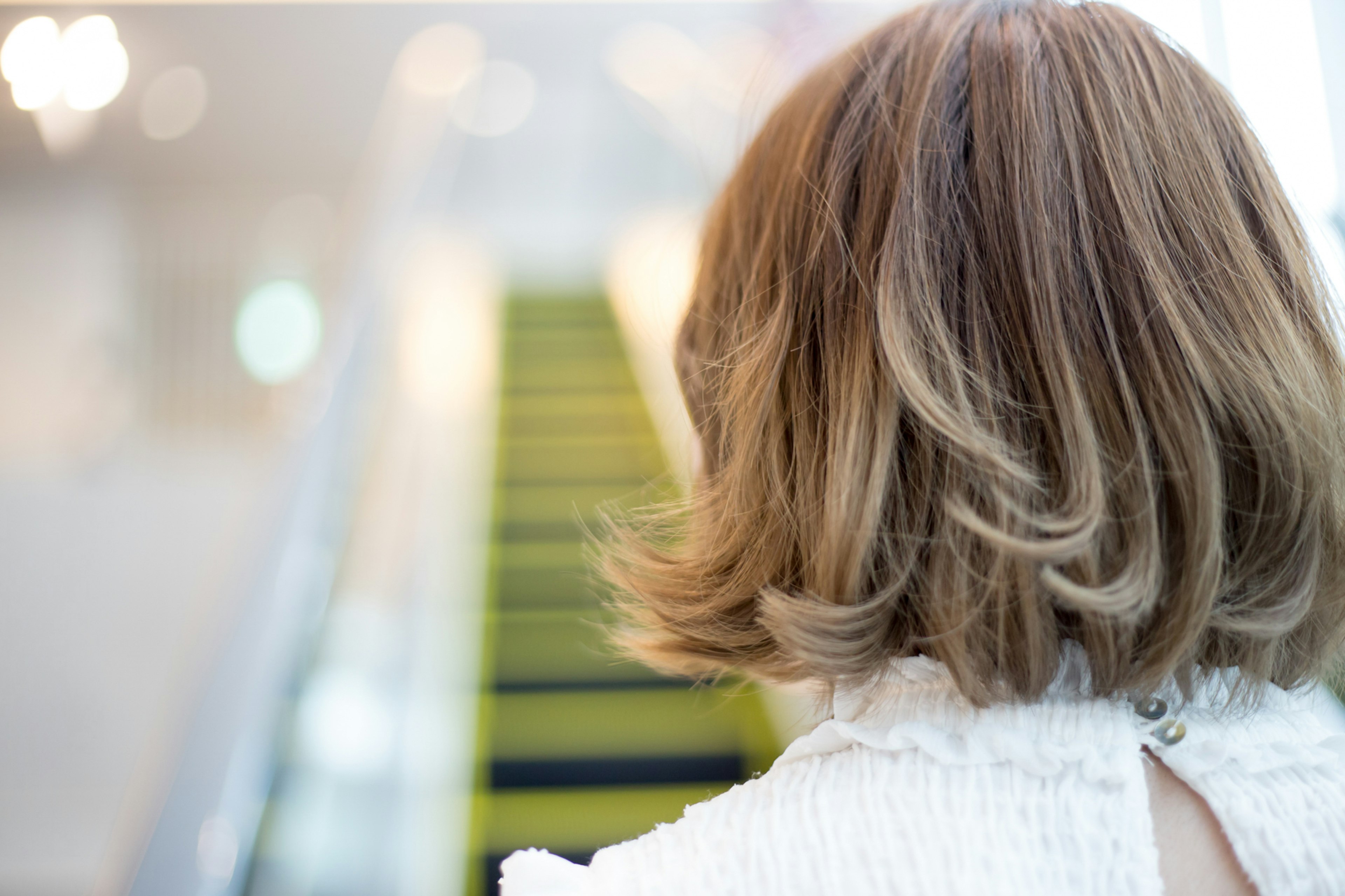 Image of a woman from behind with a view of green stairs