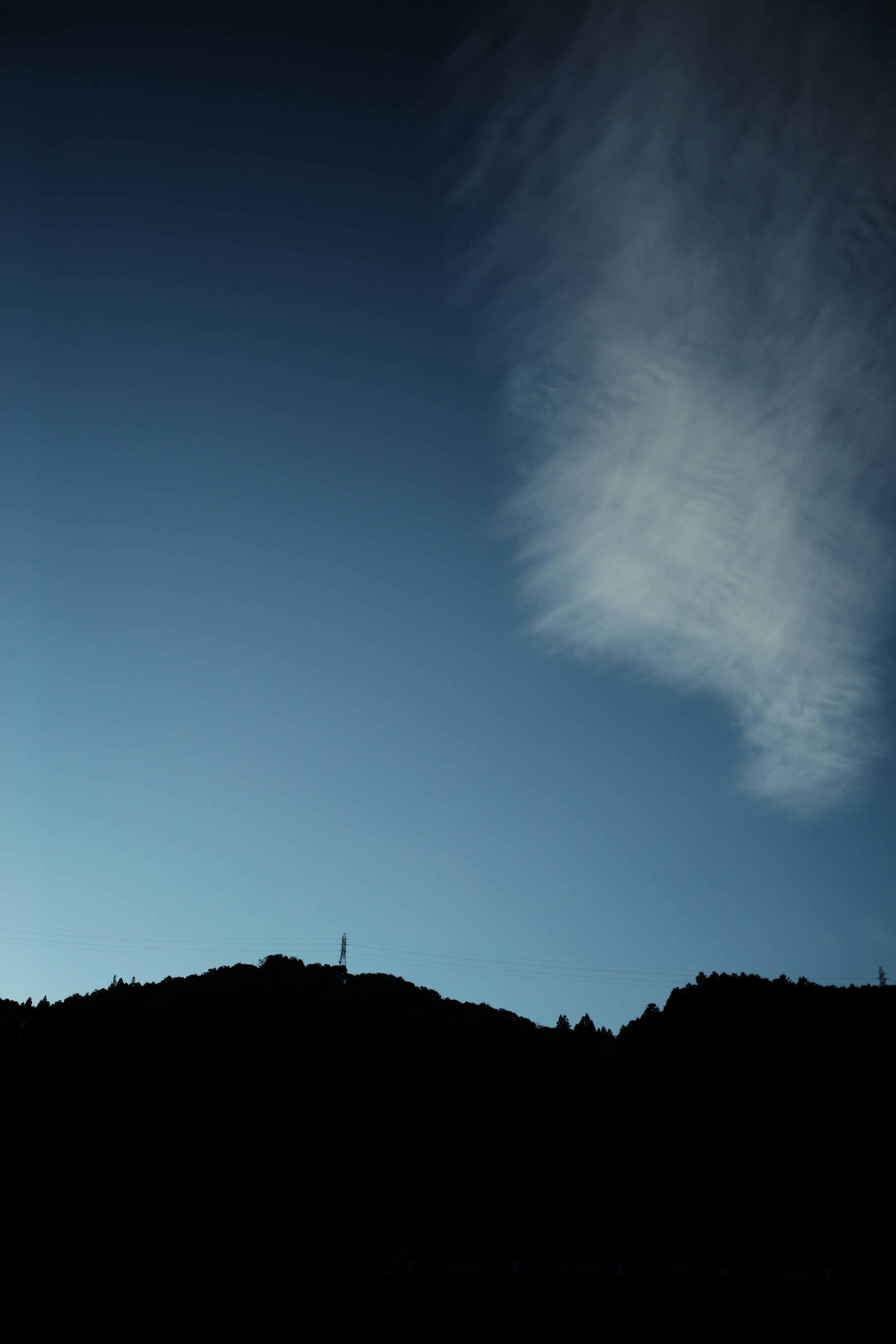 青い空と雲を背景にした山のシルエット