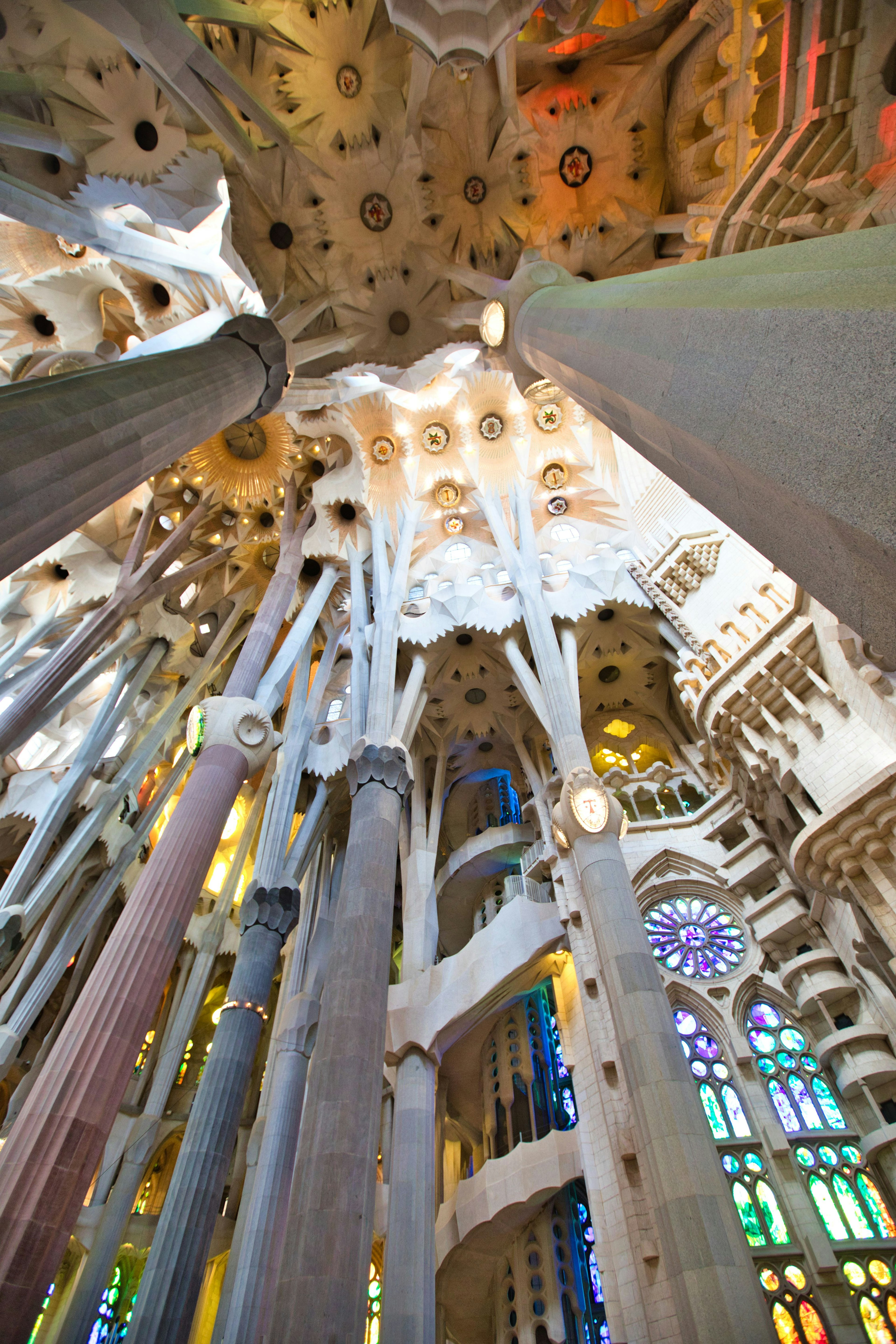 Innenansicht der Sagrada Familia mit Betonung auf Säulen und Buntglasfenstern