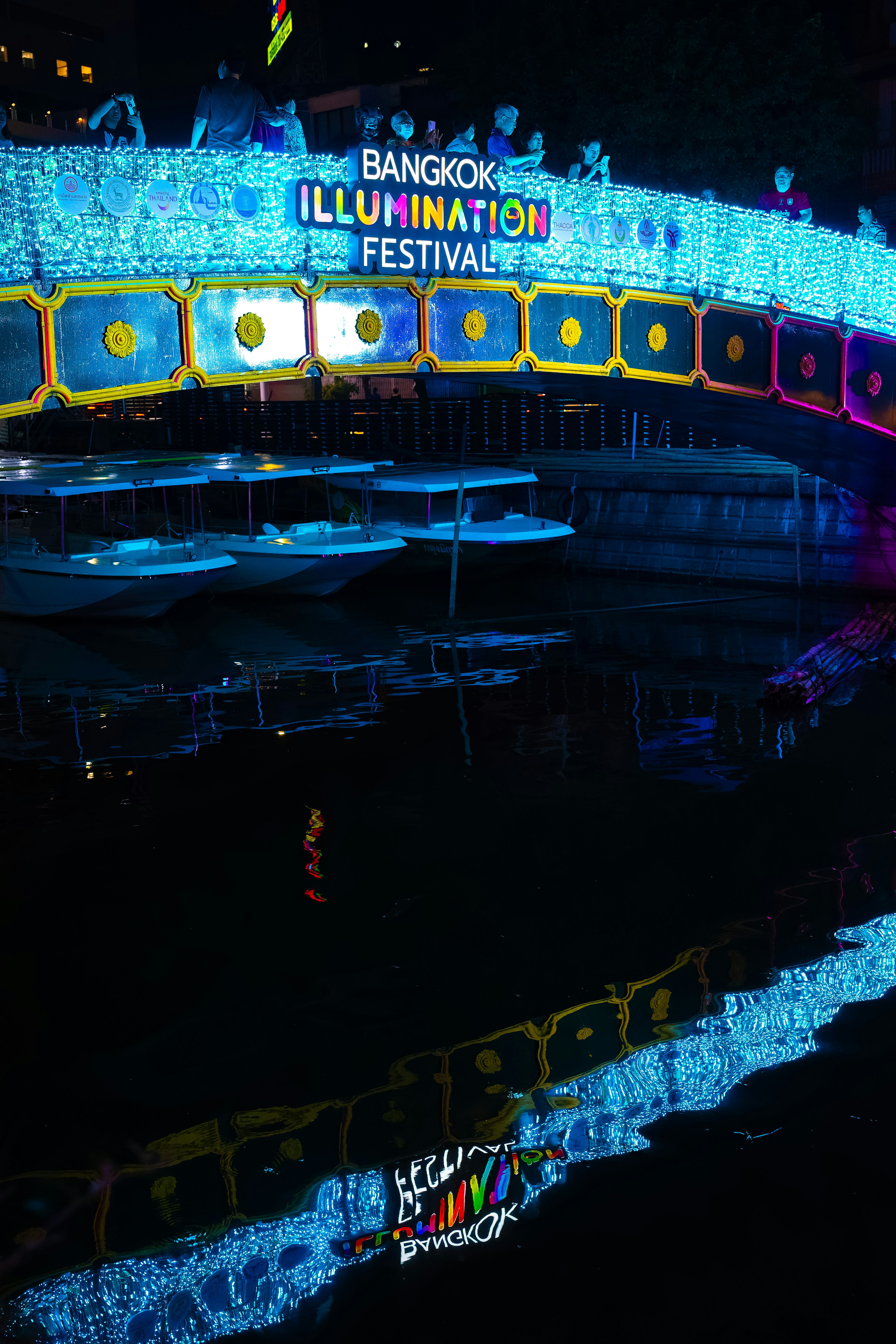 Puente brillante del Festival de Iluminación de Bangkok con su reflejo