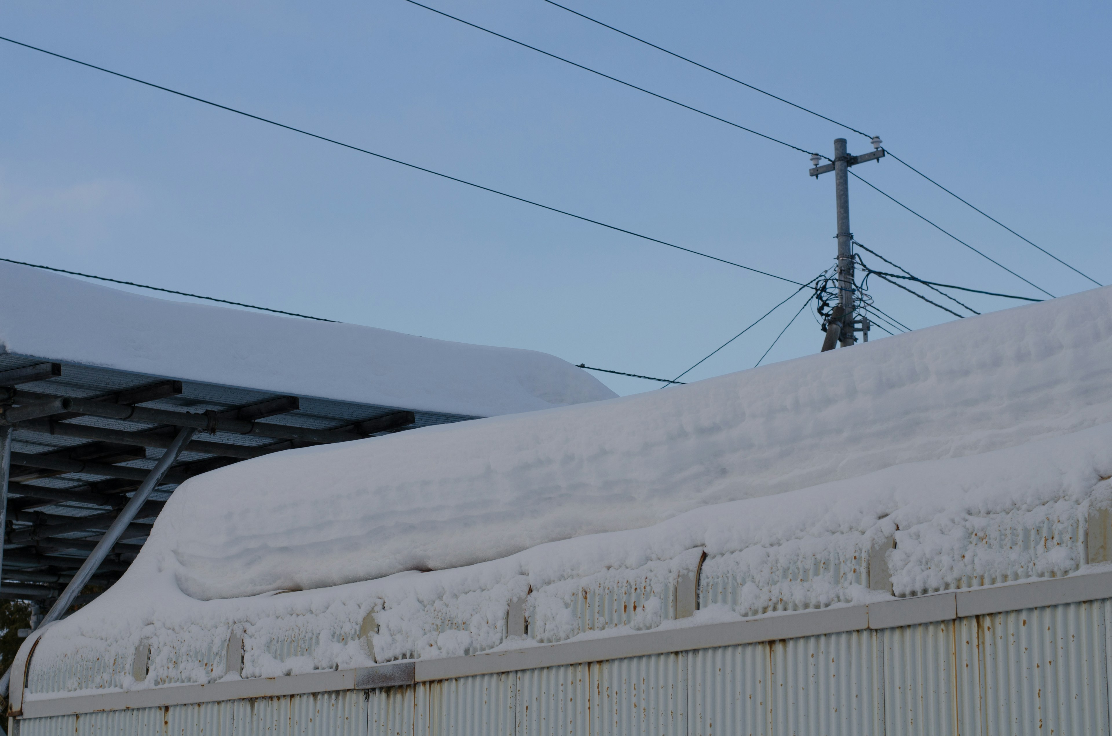 Dach bedeckt mit Schnee bei klarem blauen Himmel