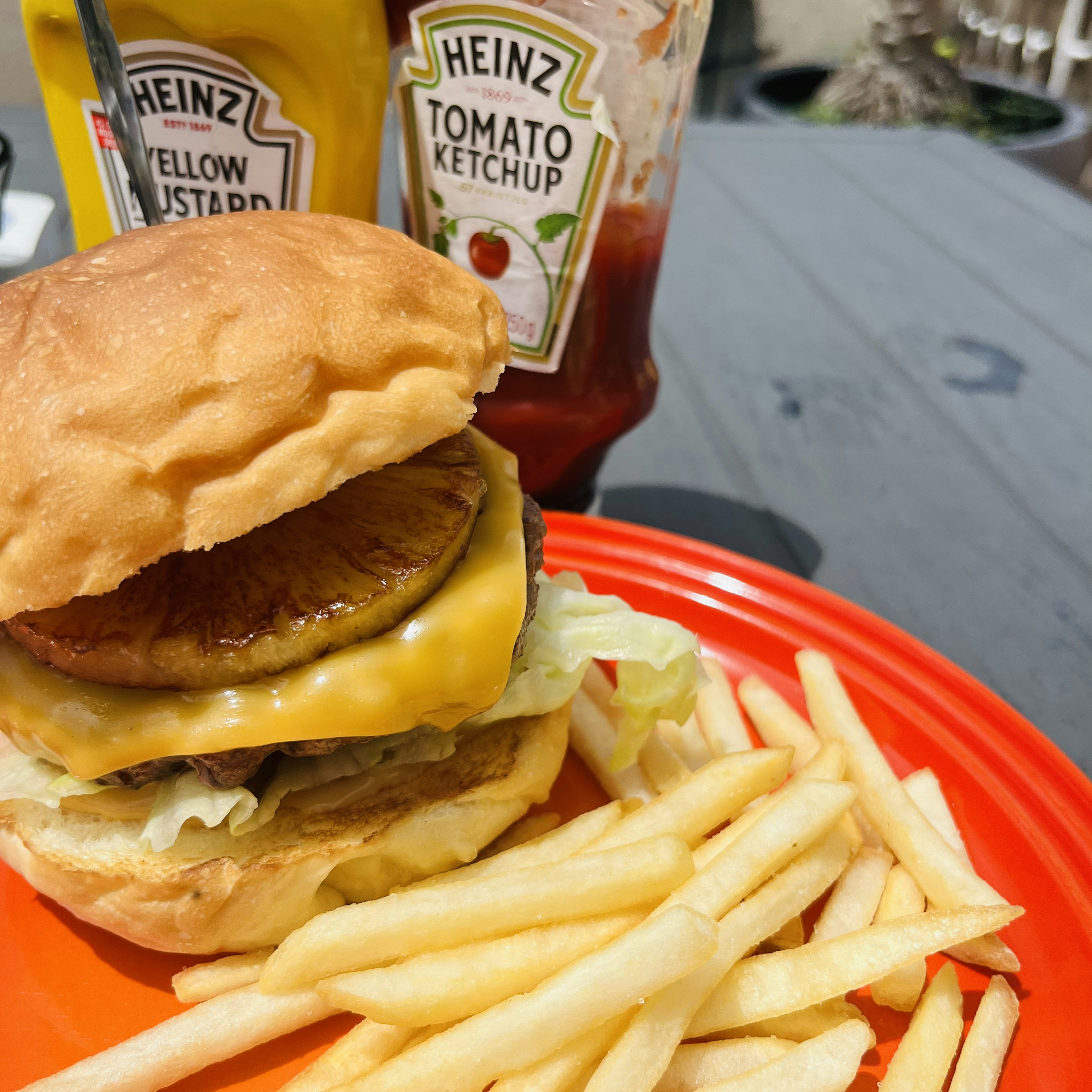 ハンバーガーとフライドポテトの盛り付け 濃厚なチーズとレタス トマトケチャップとイエローマスタードのボトル