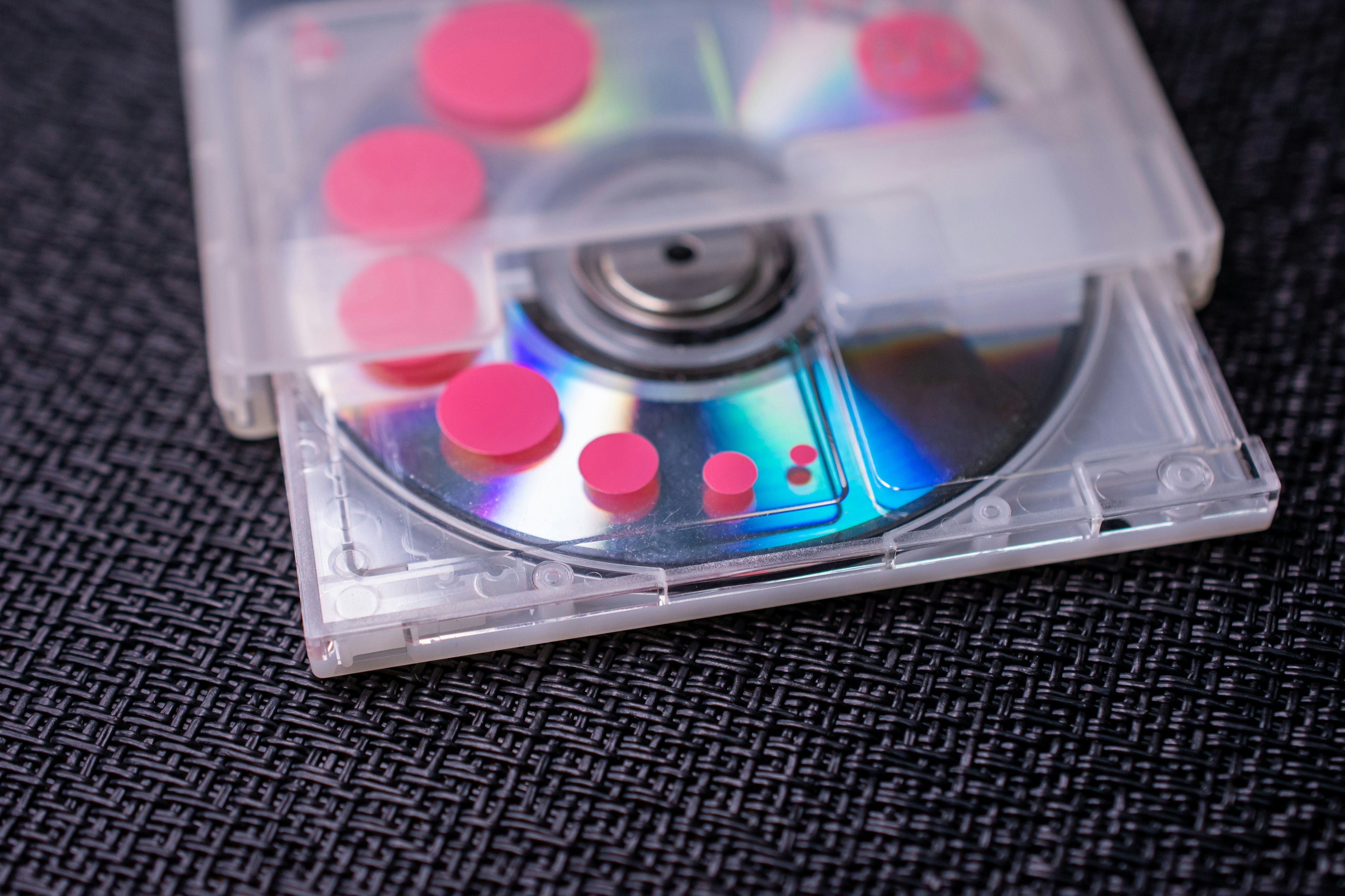 CD en una caja transparente con puntos de colores