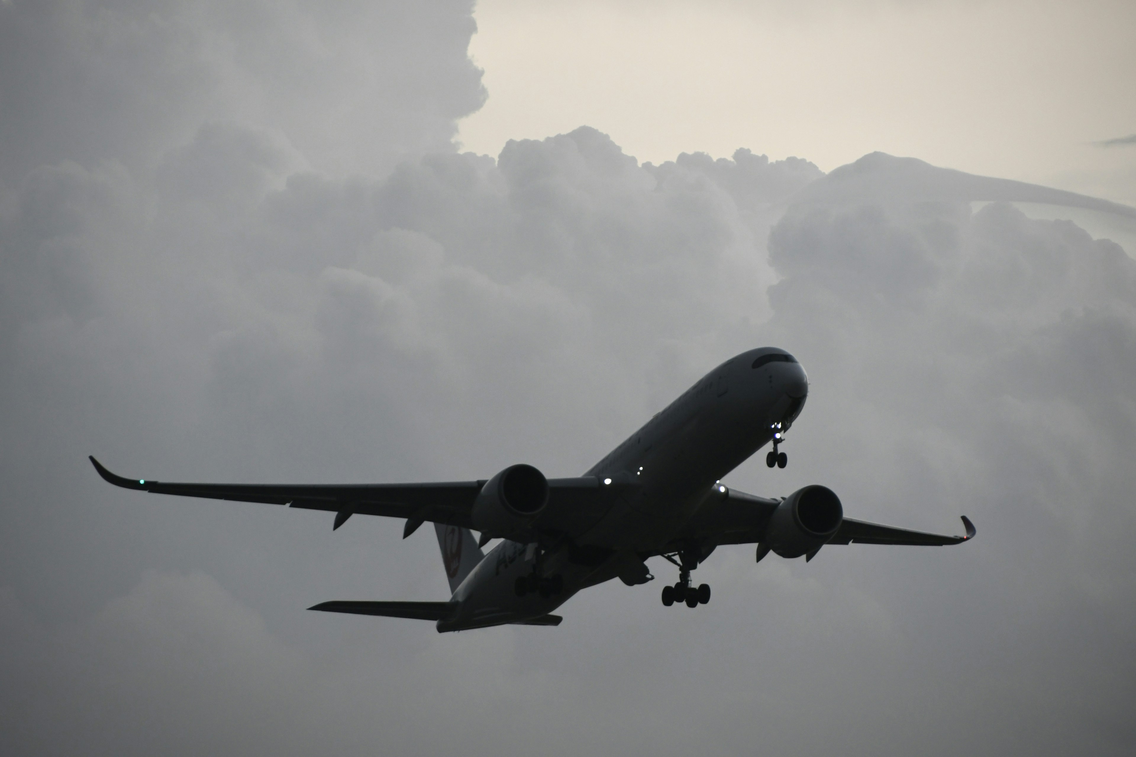 Silhouette d'un avion volant à travers des nuages