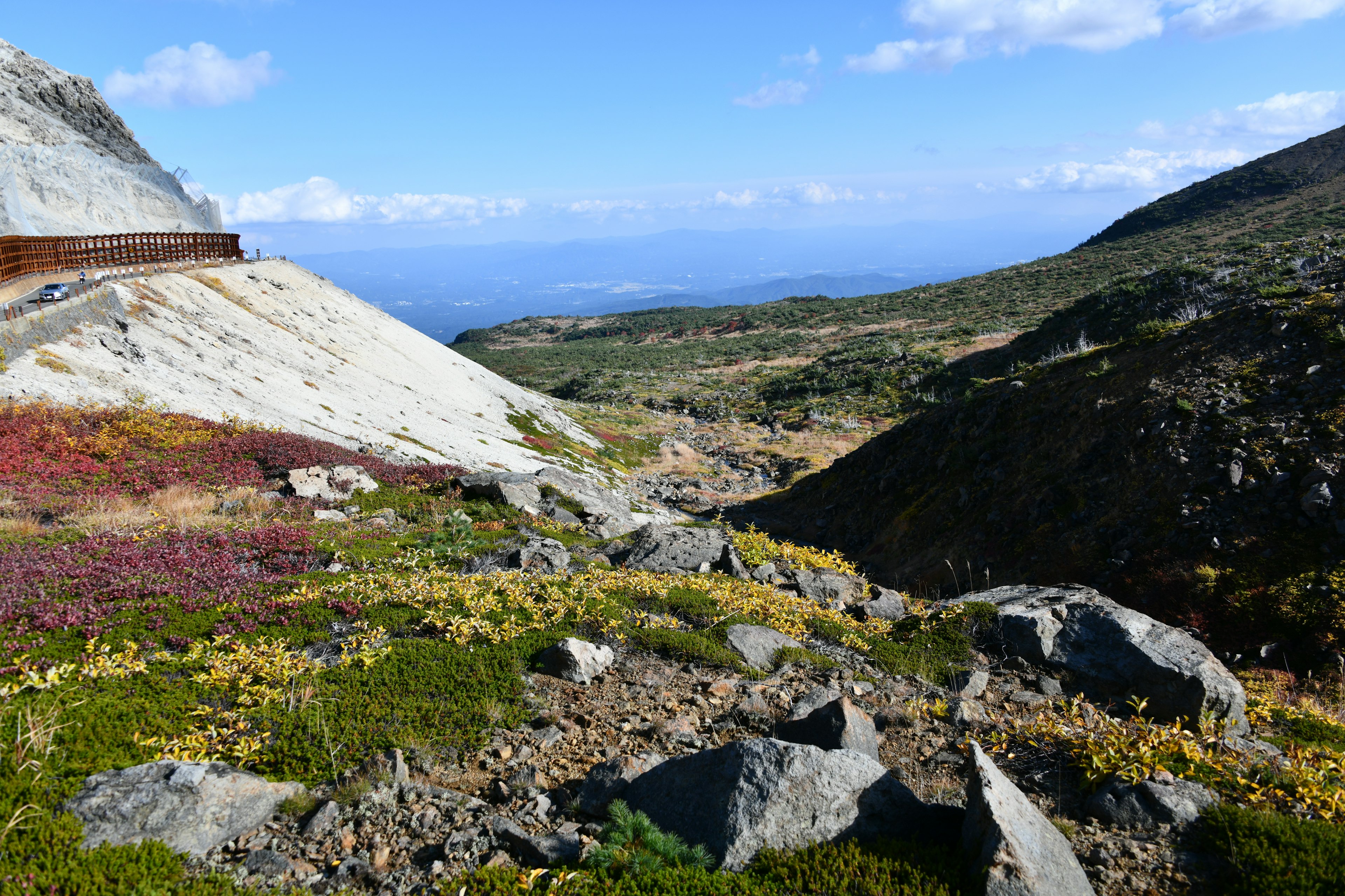 山の斜面と青空が広がる風景 低い植物と岩が点在する