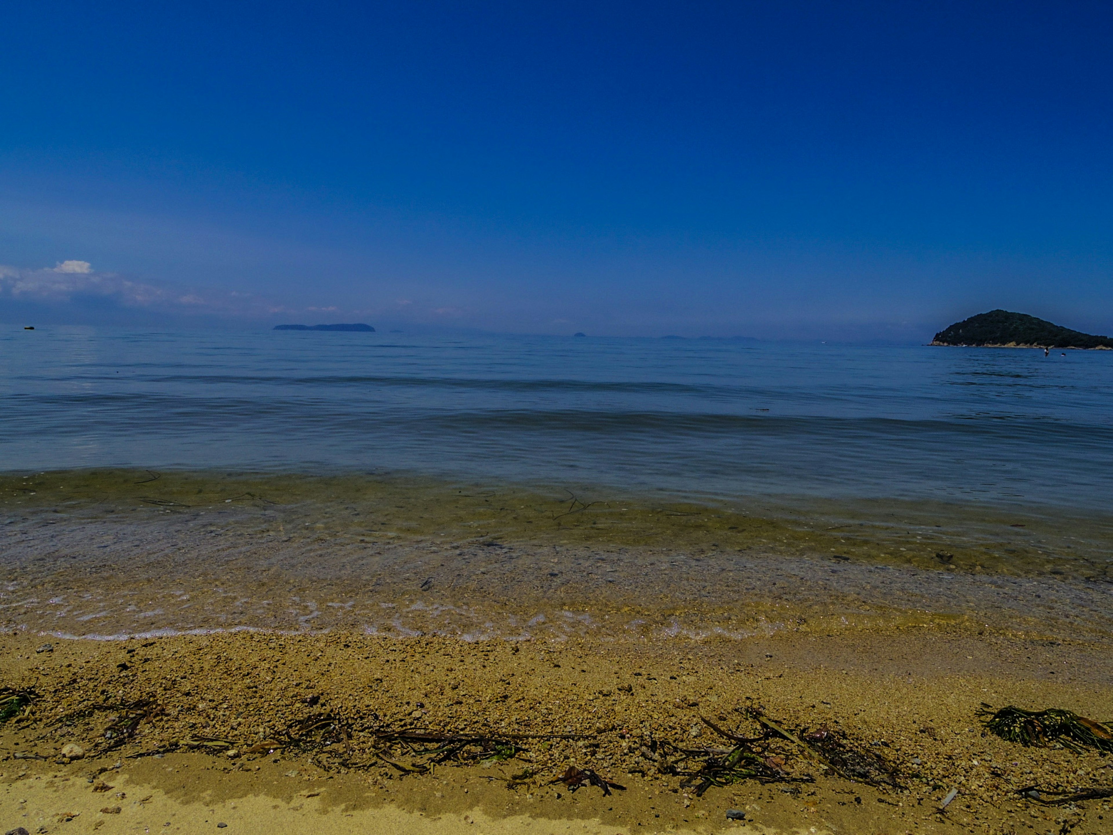 Malersiche Strandansicht mit blauem Himmel und ruhigem Meer