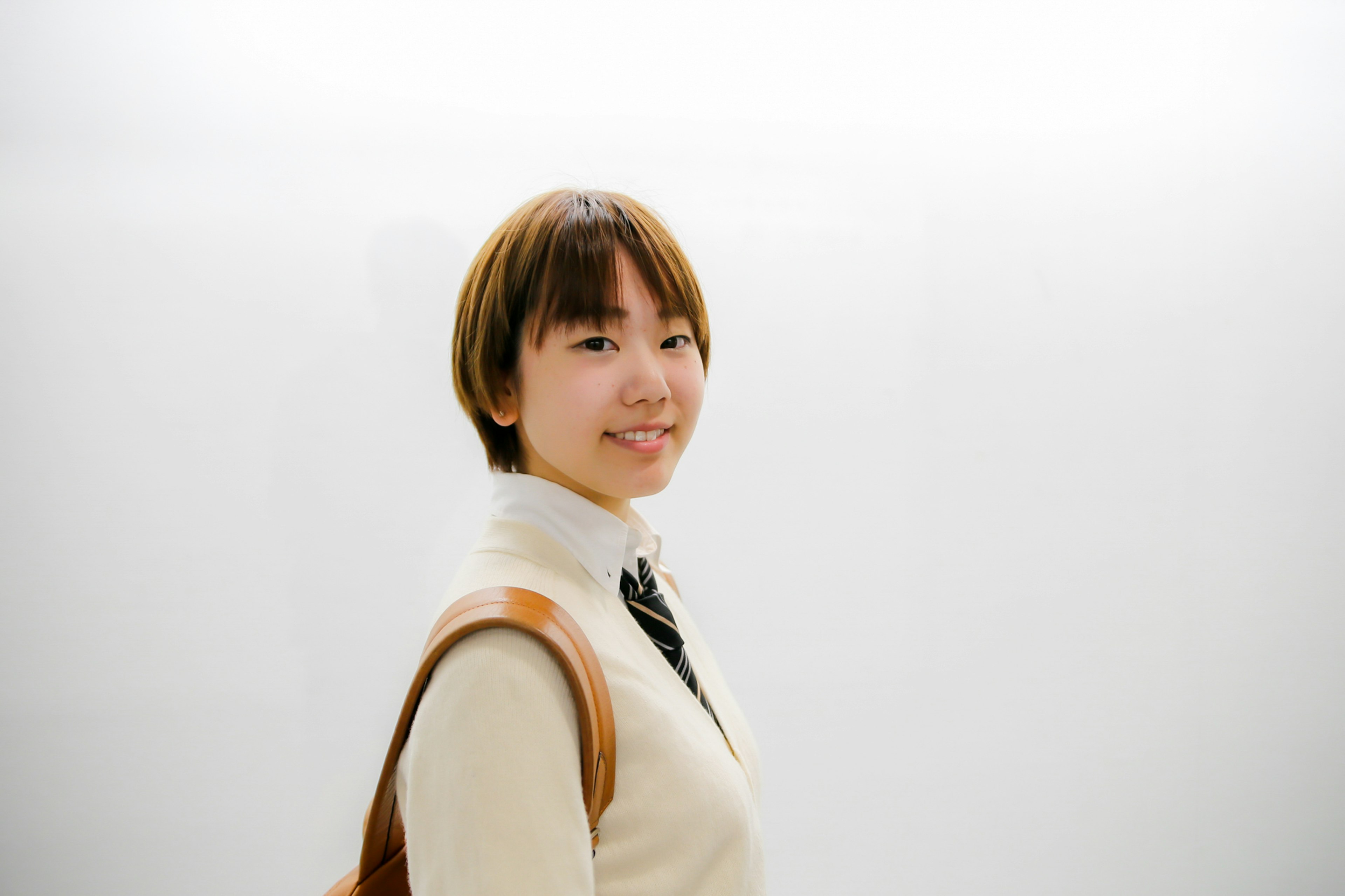 Portrait of a young woman smiling in front of a white background