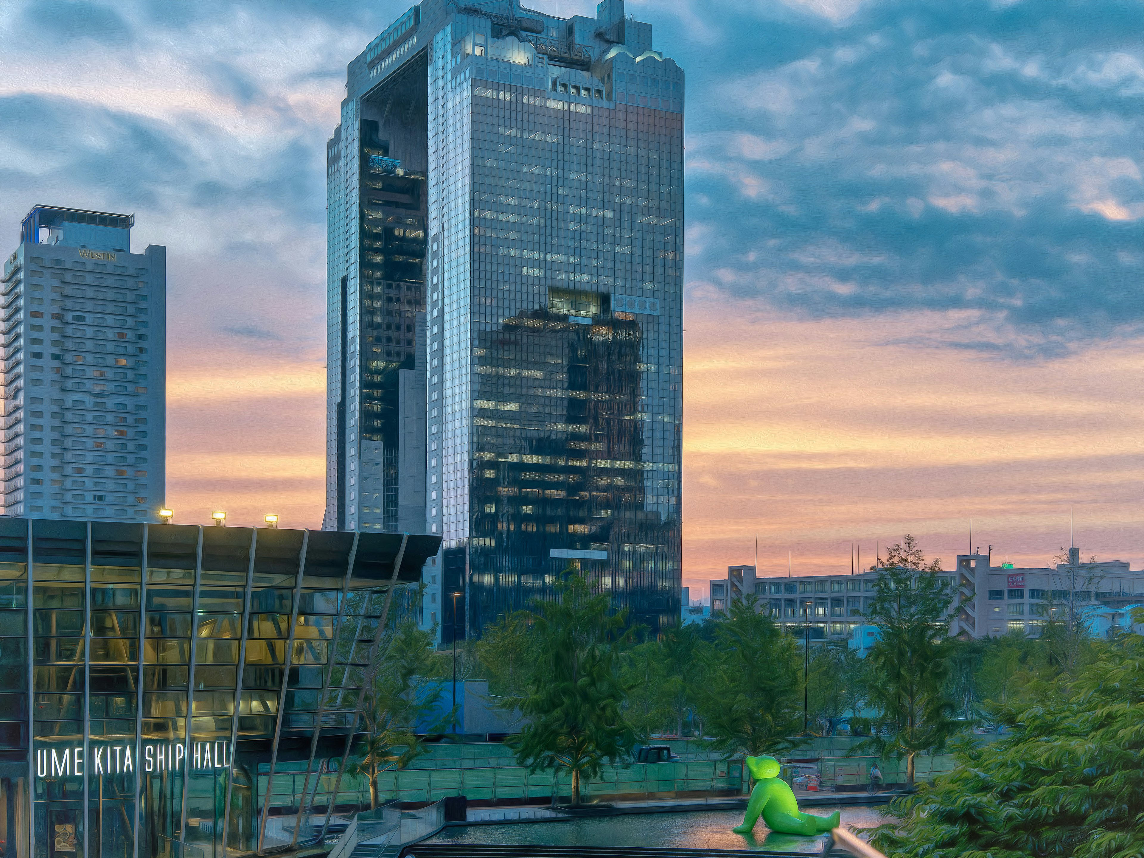 Edificio de gran altura bajo un cielo de atardecer con una escultura verde flotando en un estanque del parque