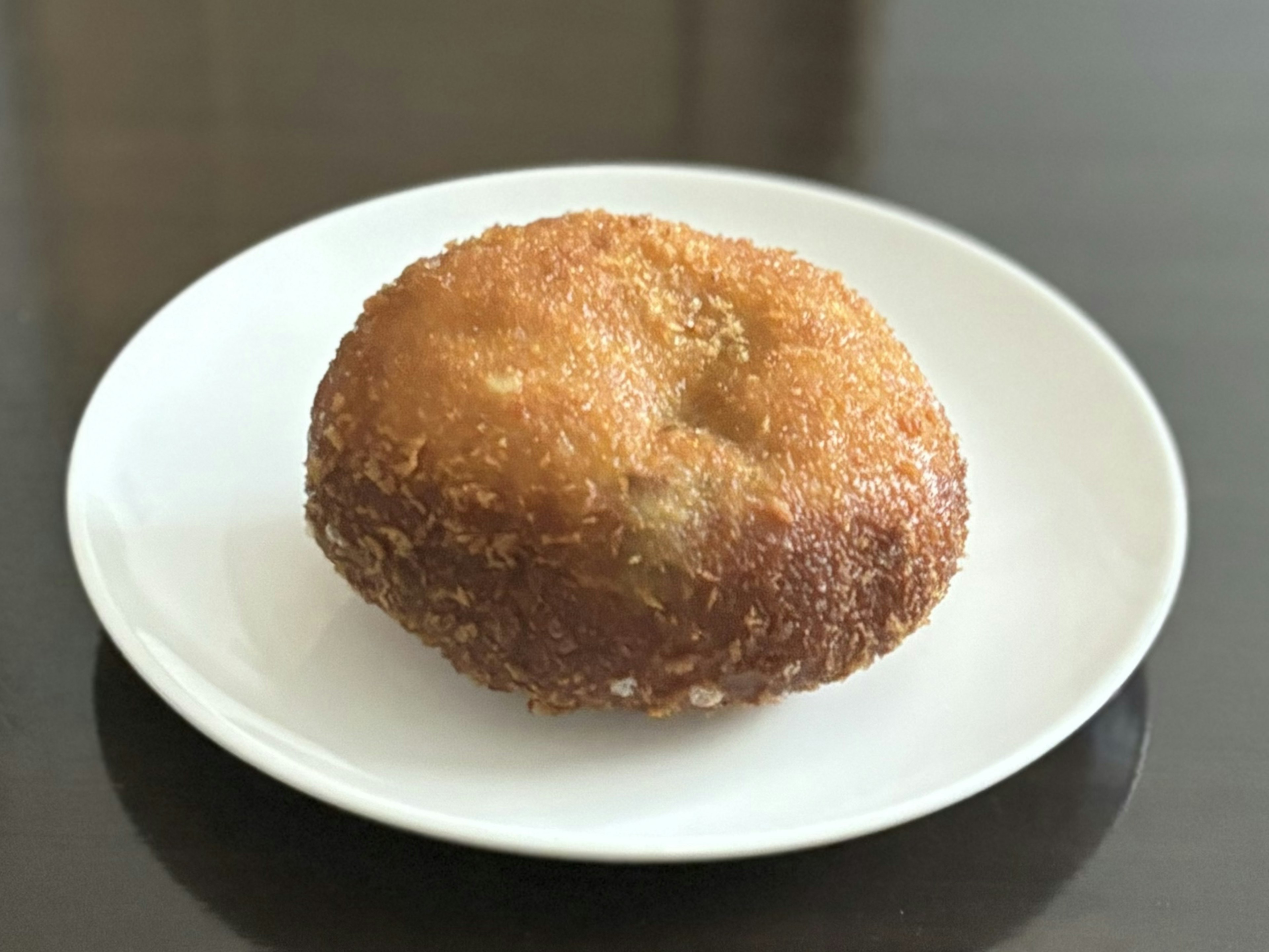 Pasta fritta a forma di ciambella su un piatto bianco