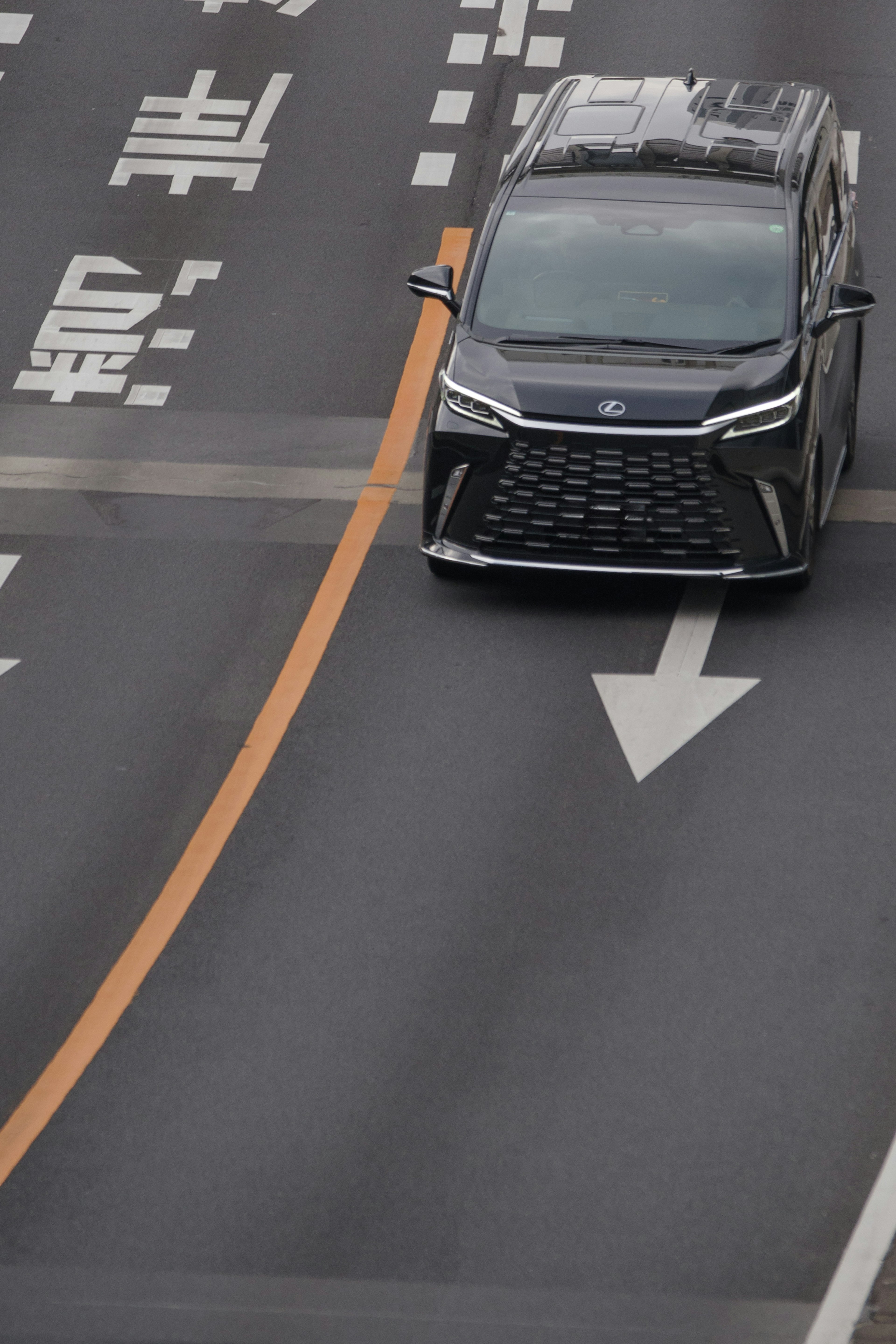 Black car driving on road with directional arrow