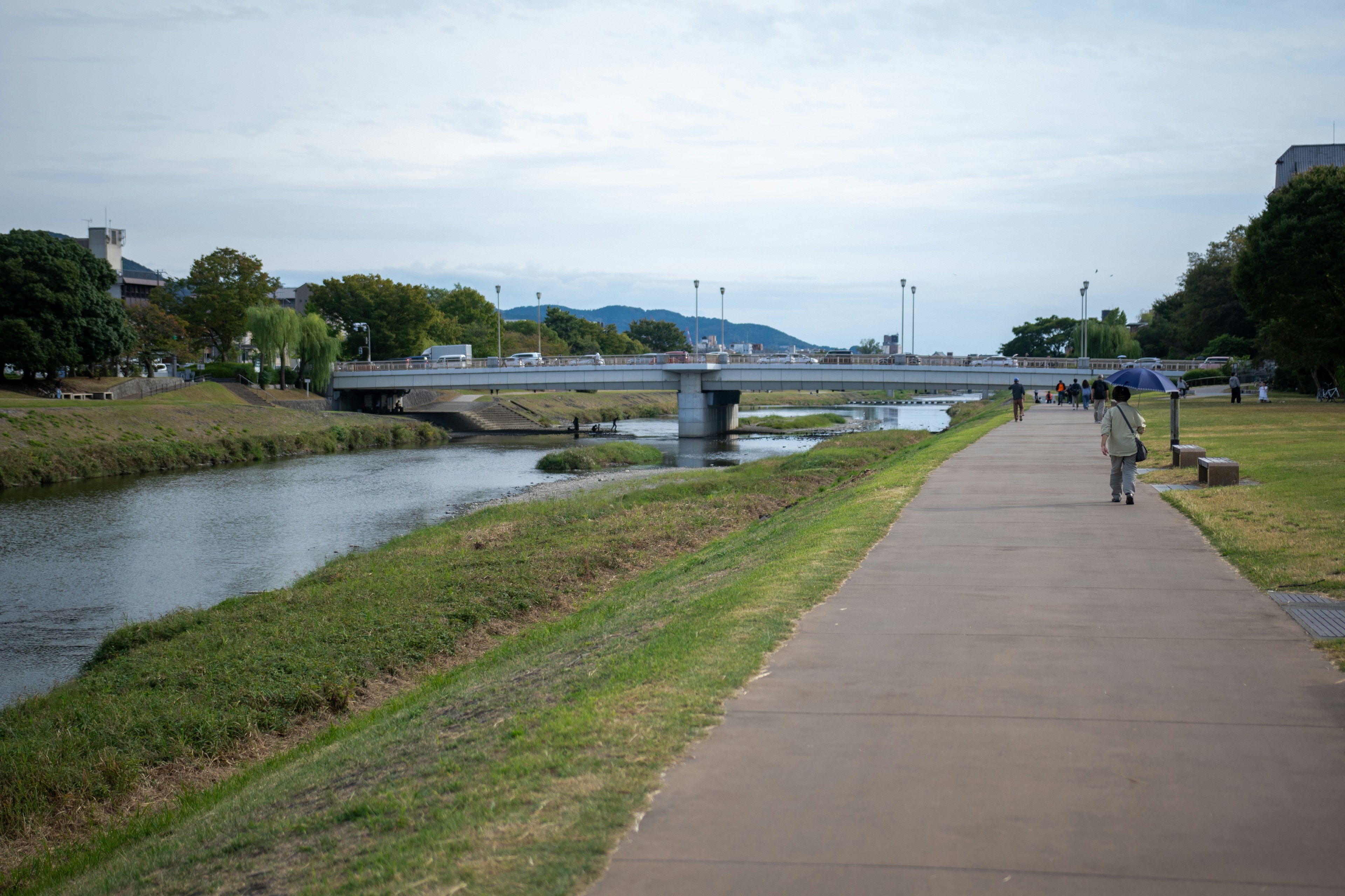 Scenic riverside walkway with a bridge in view