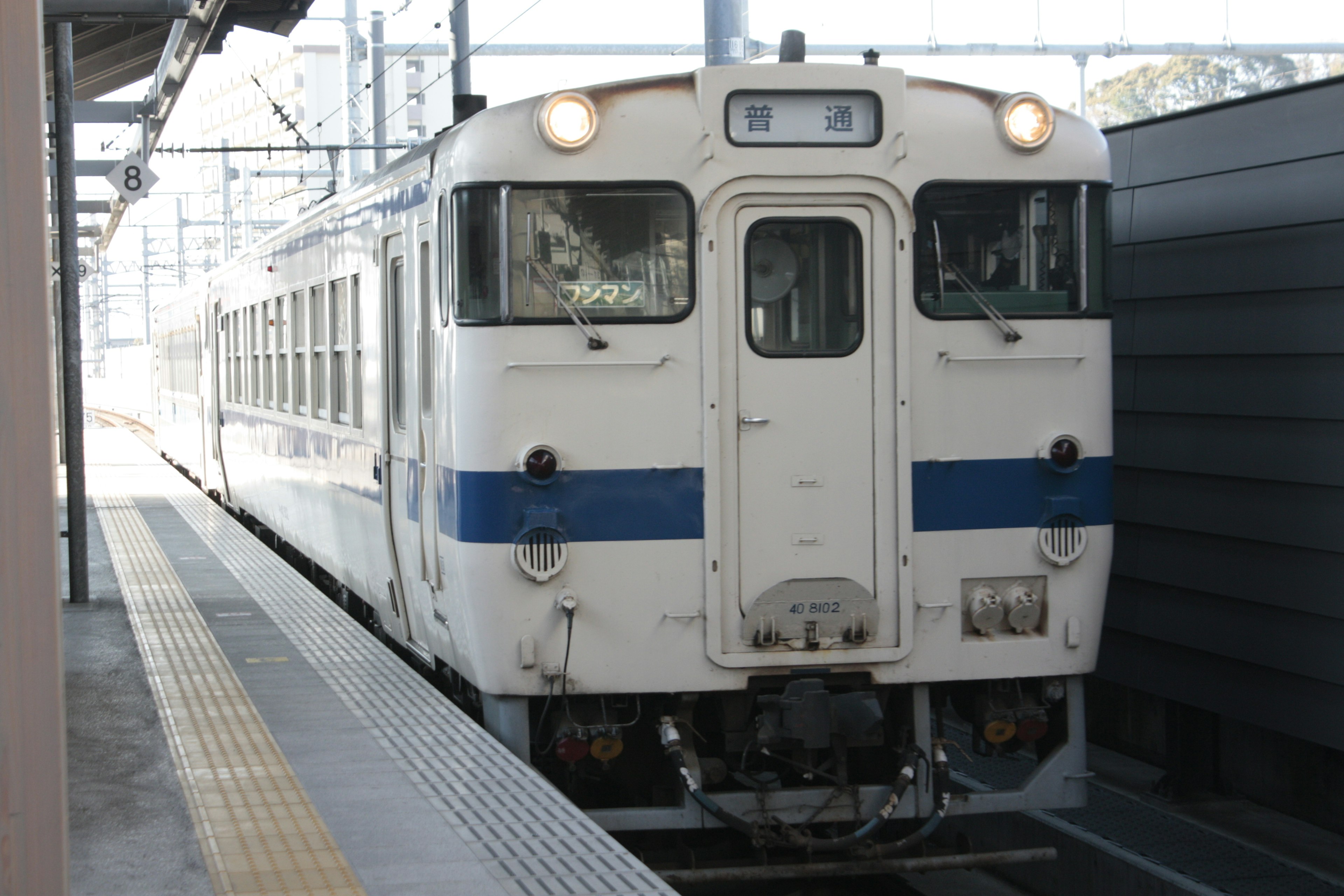 白と青の列車が駅に停車中