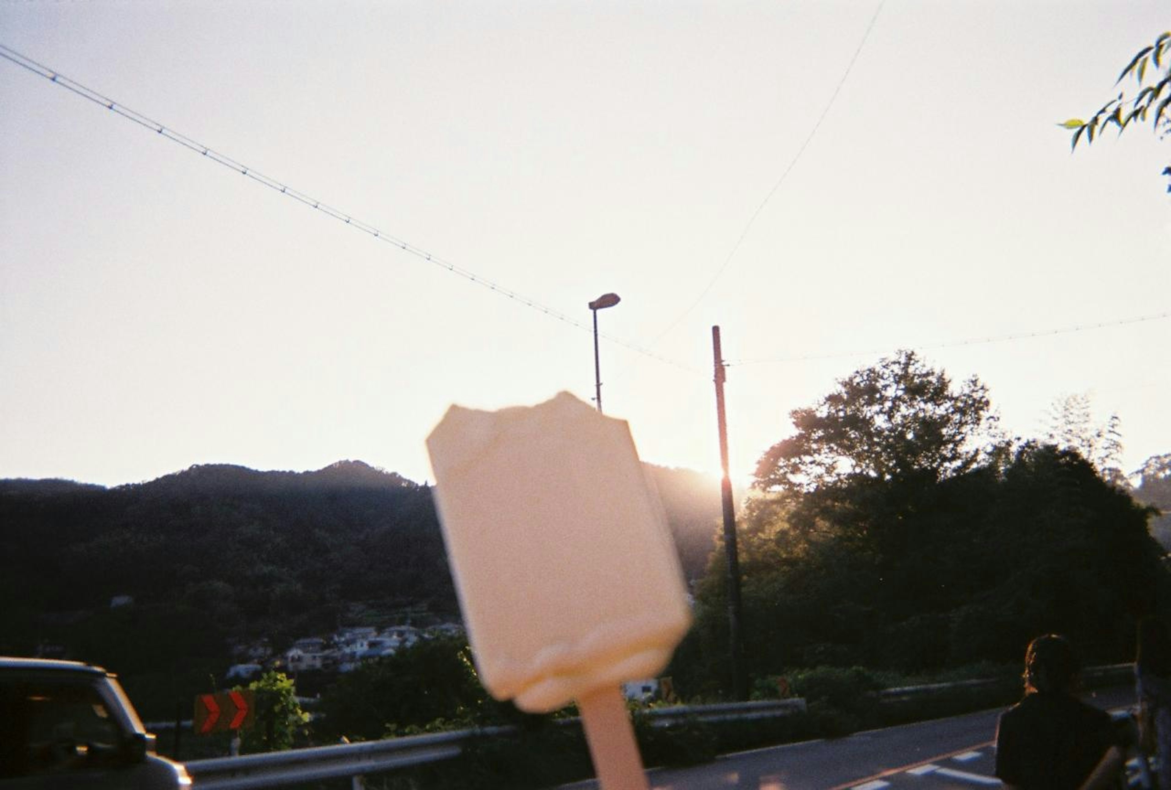 Partially eaten ice cream bar with sunset in the background