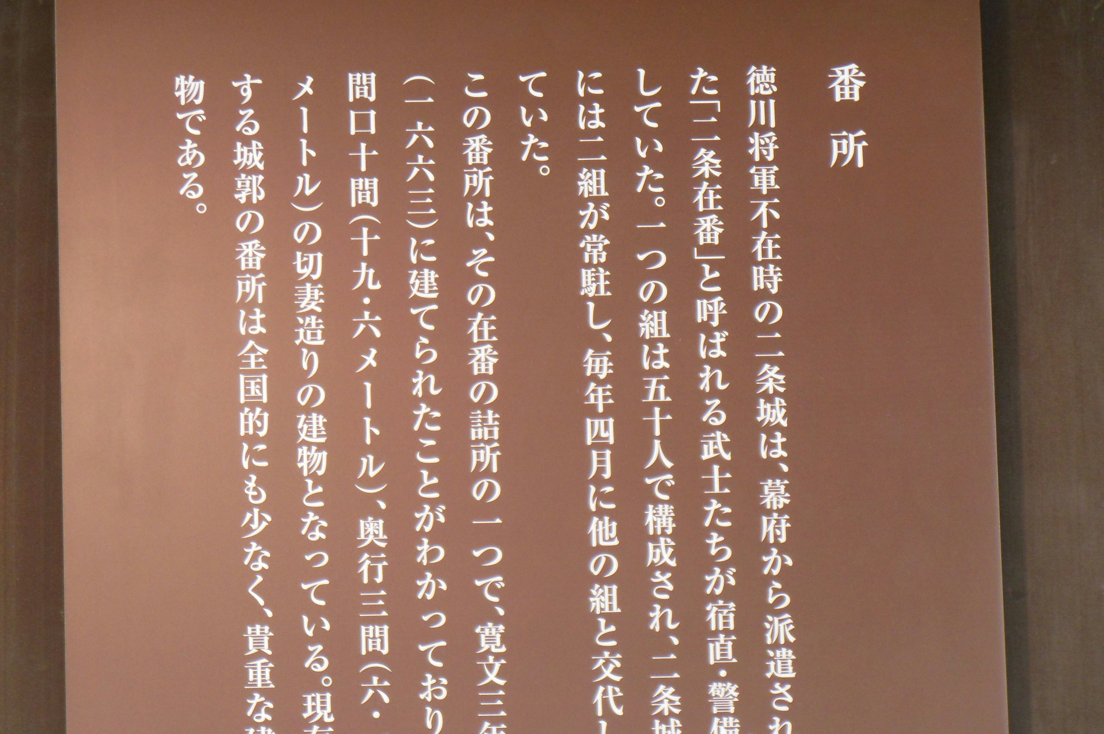 Dieses Bild zeigt japanischen Text, der auf einer braunen Wand geschrieben ist