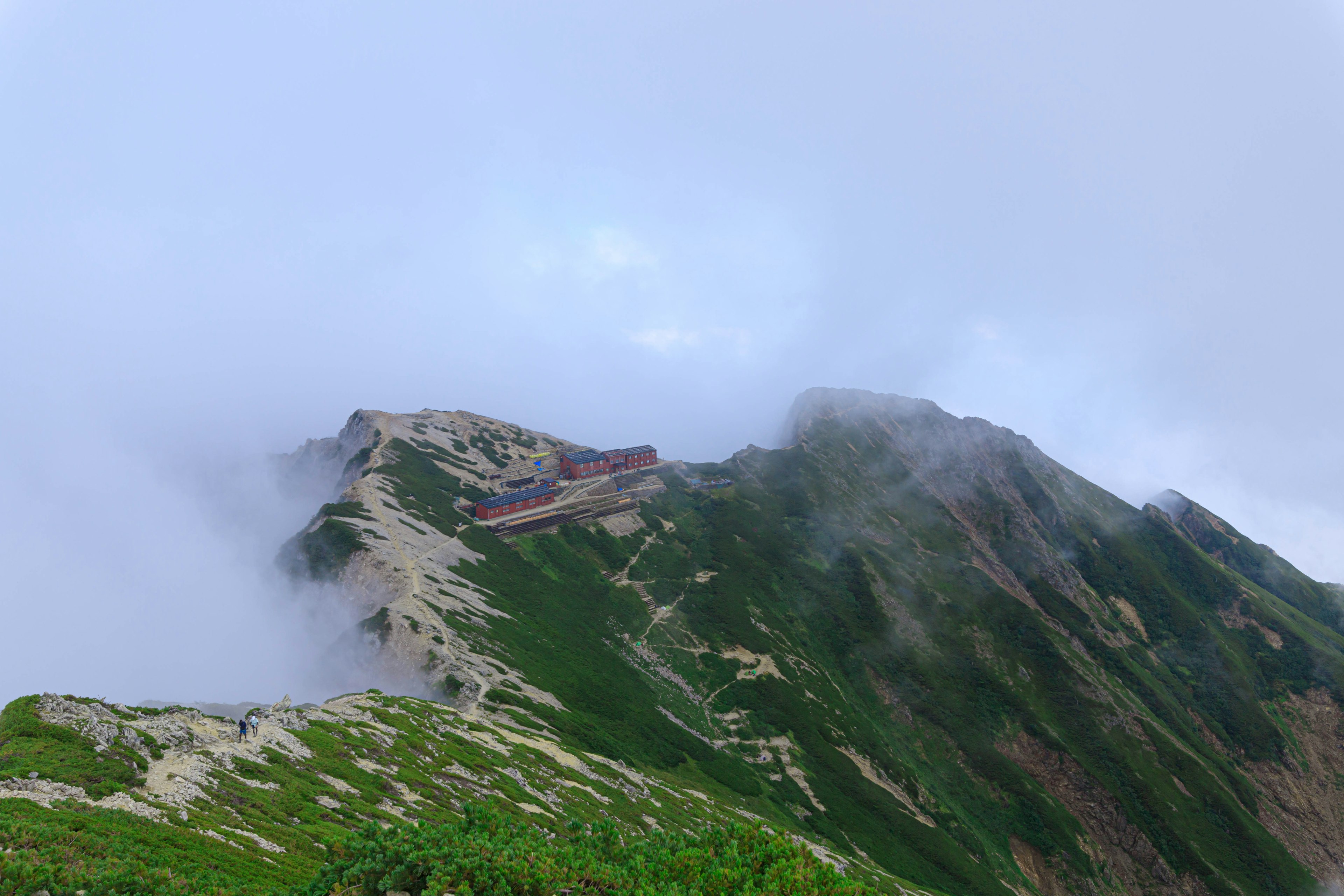 Mountain landscape shrouded in mist with green slopes