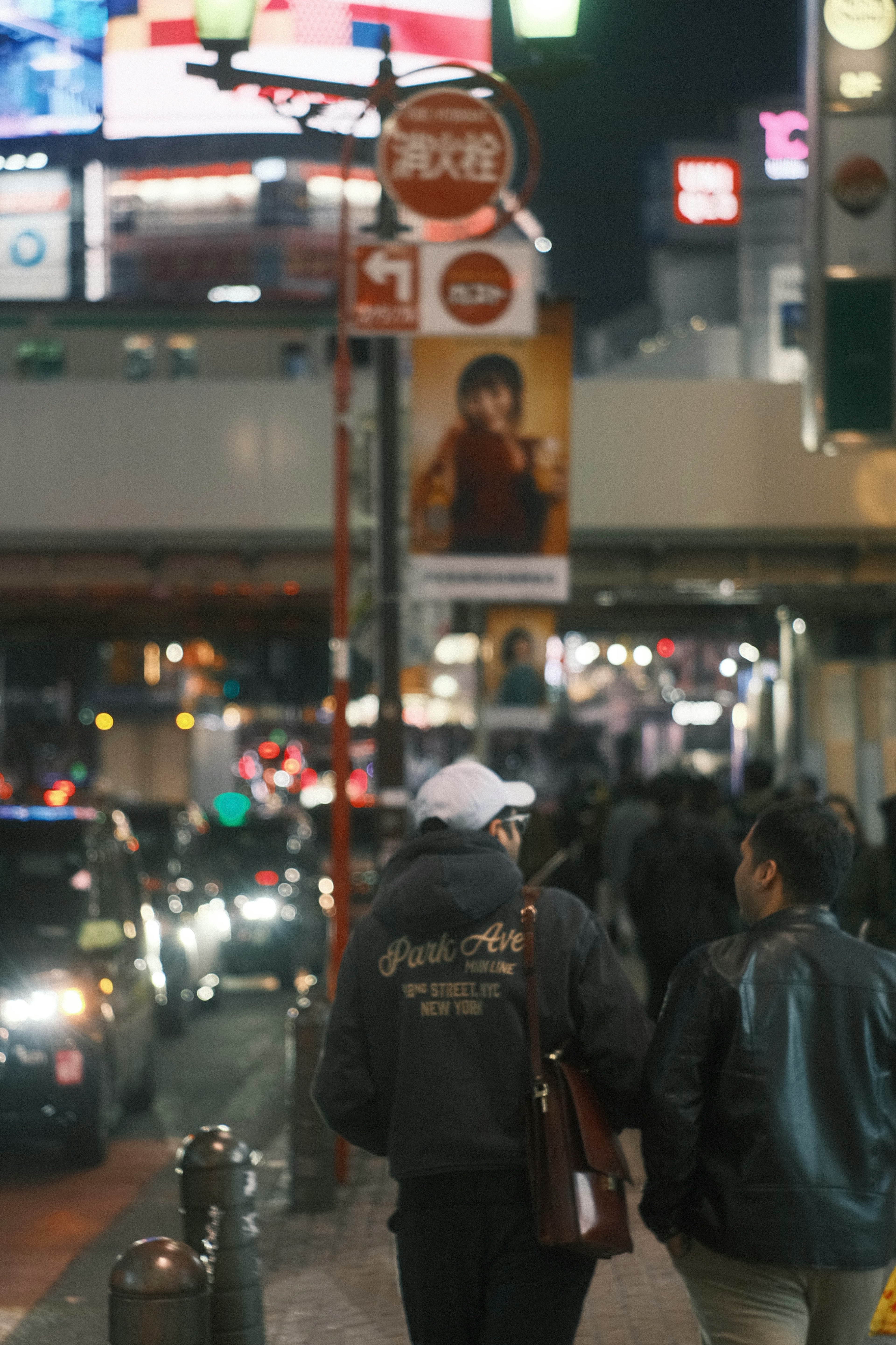 Pemandangan malam dengan orang-orang berjalan dan papan iklan terang