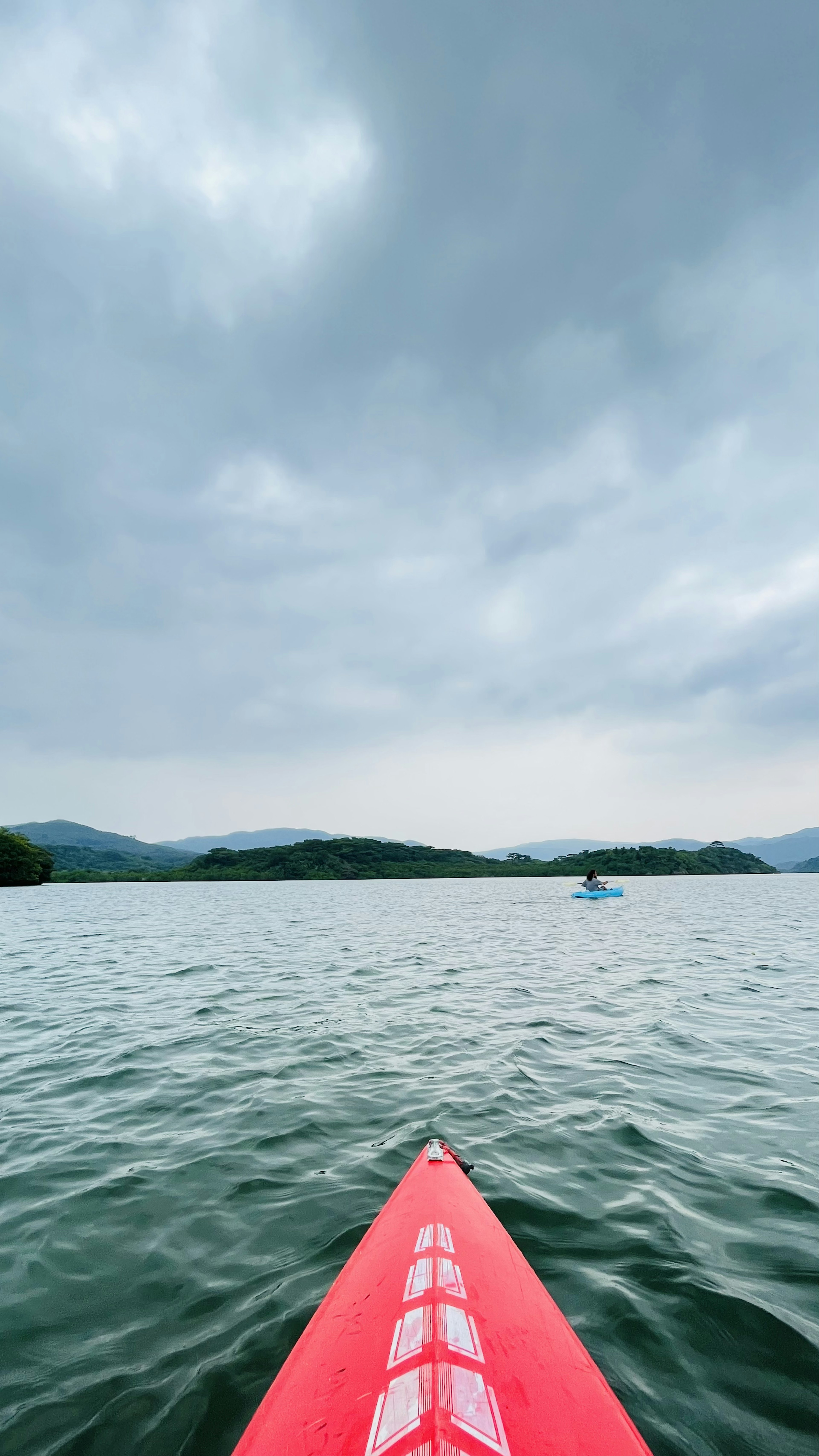 赤いカヤックが静かな湖を進む風景