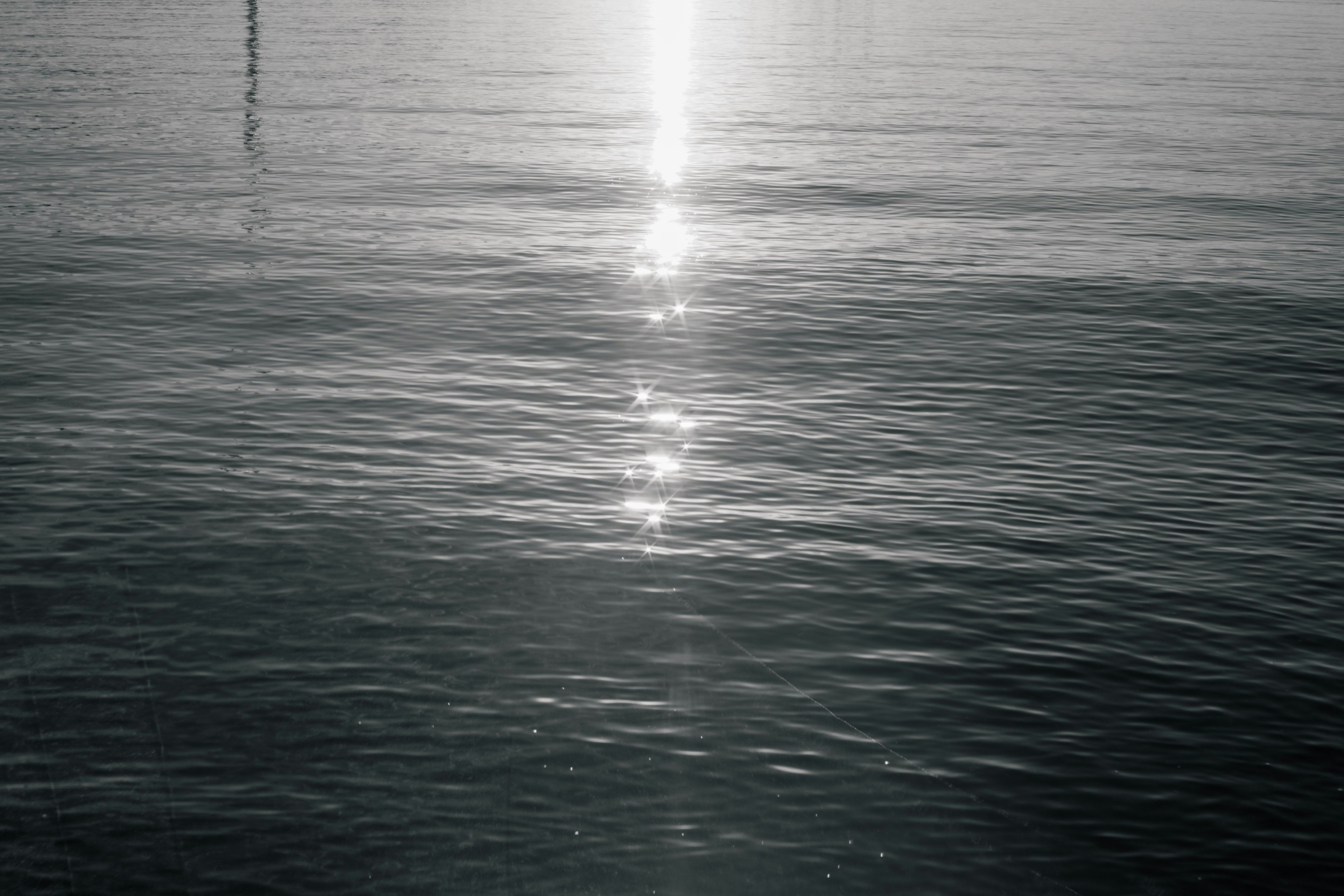 A serene water surface reflecting a band of light