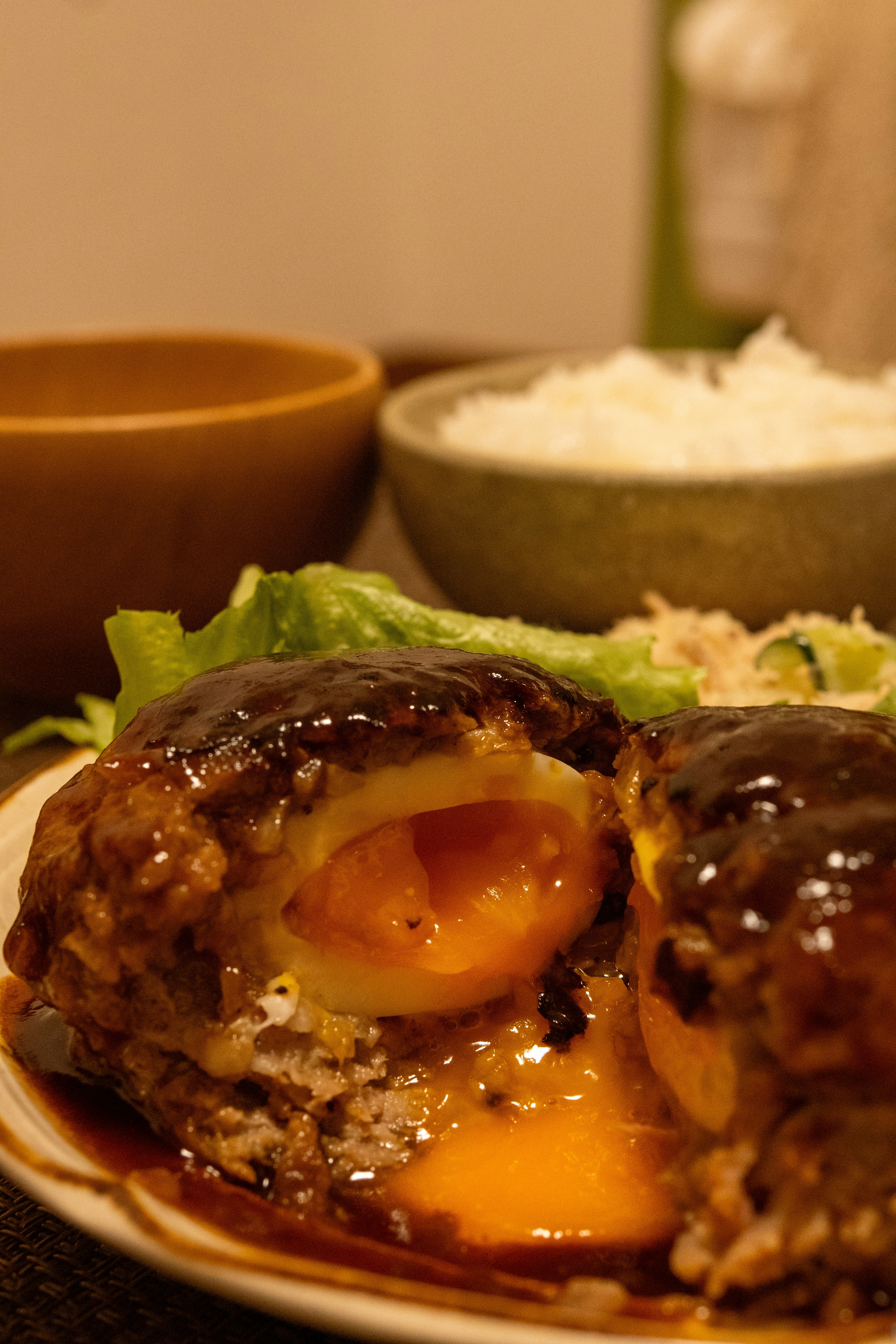 Cross-section of a hamburger steak with runny egg and side of rice