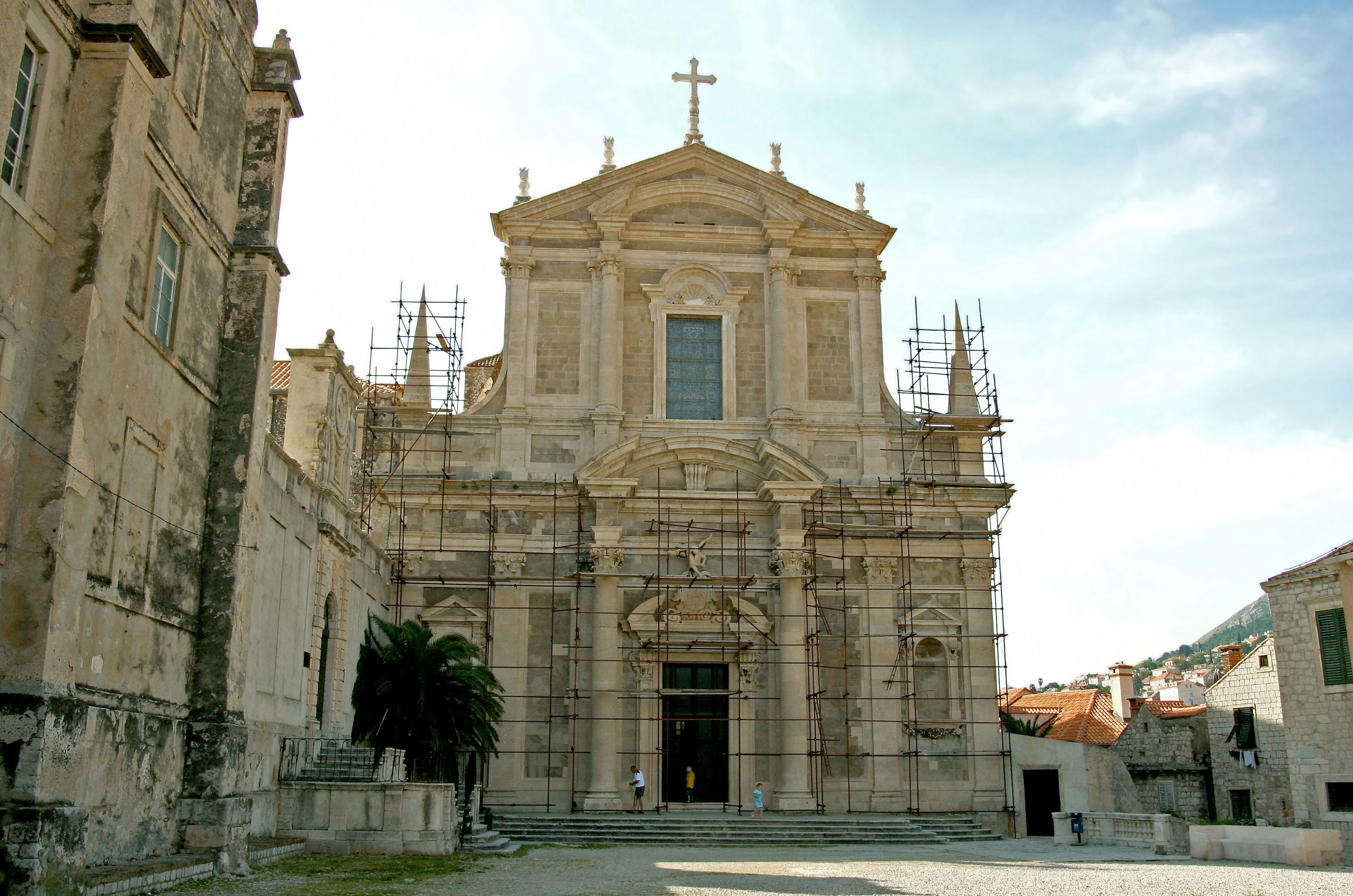 Facade of a church under restoration featuring intricate carvings and a cross